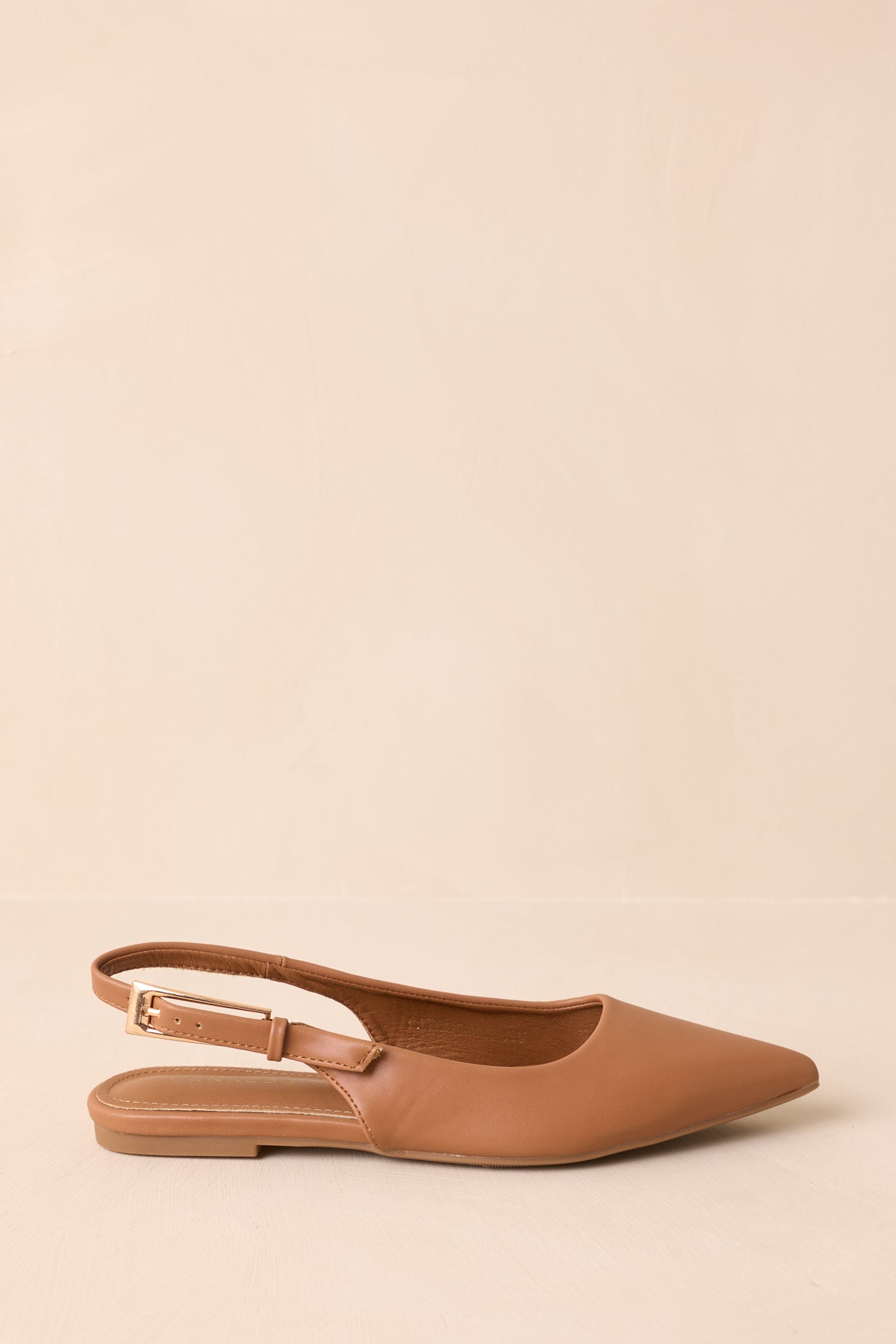 Cropped side view highlighting the adjustable buckle strap and smooth faux-leather upper.