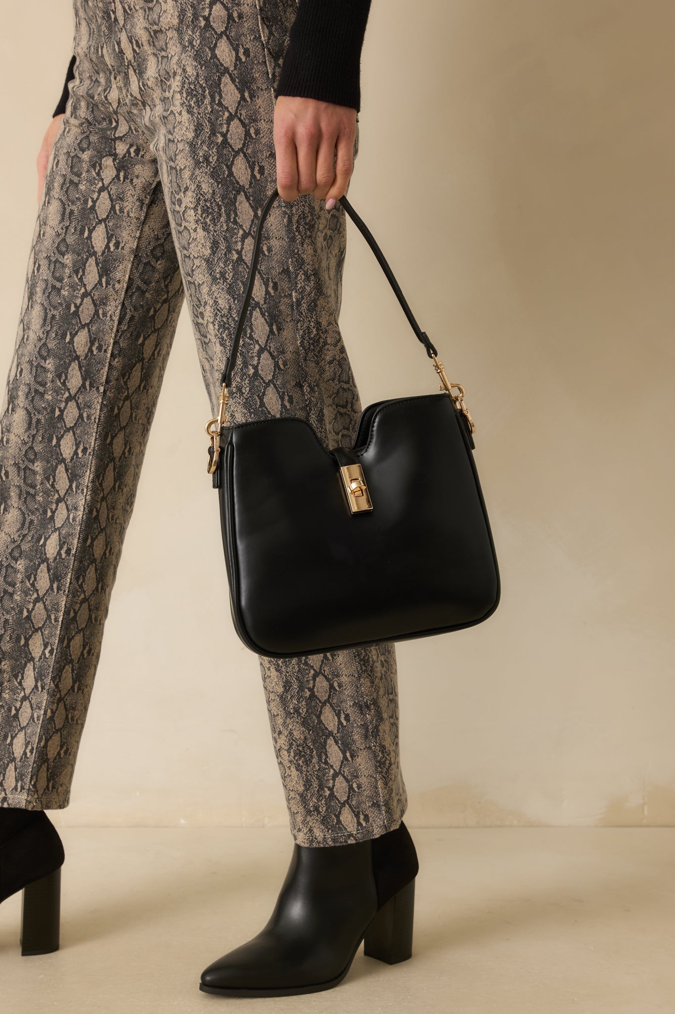 Cropped image highlighting the side view with the attached shoulder strap and gold hardware accents.