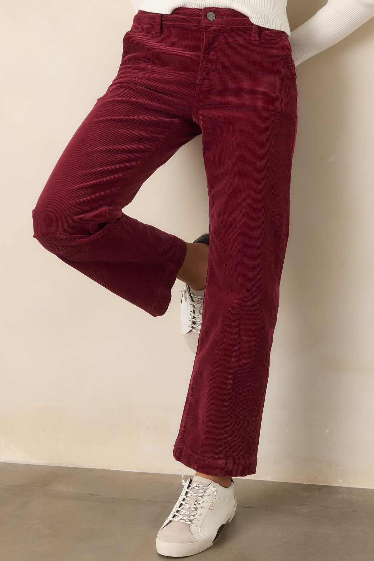 Cropped straight-leg corduroy pants highlighting the textured fabric, zip fly, and button closure.