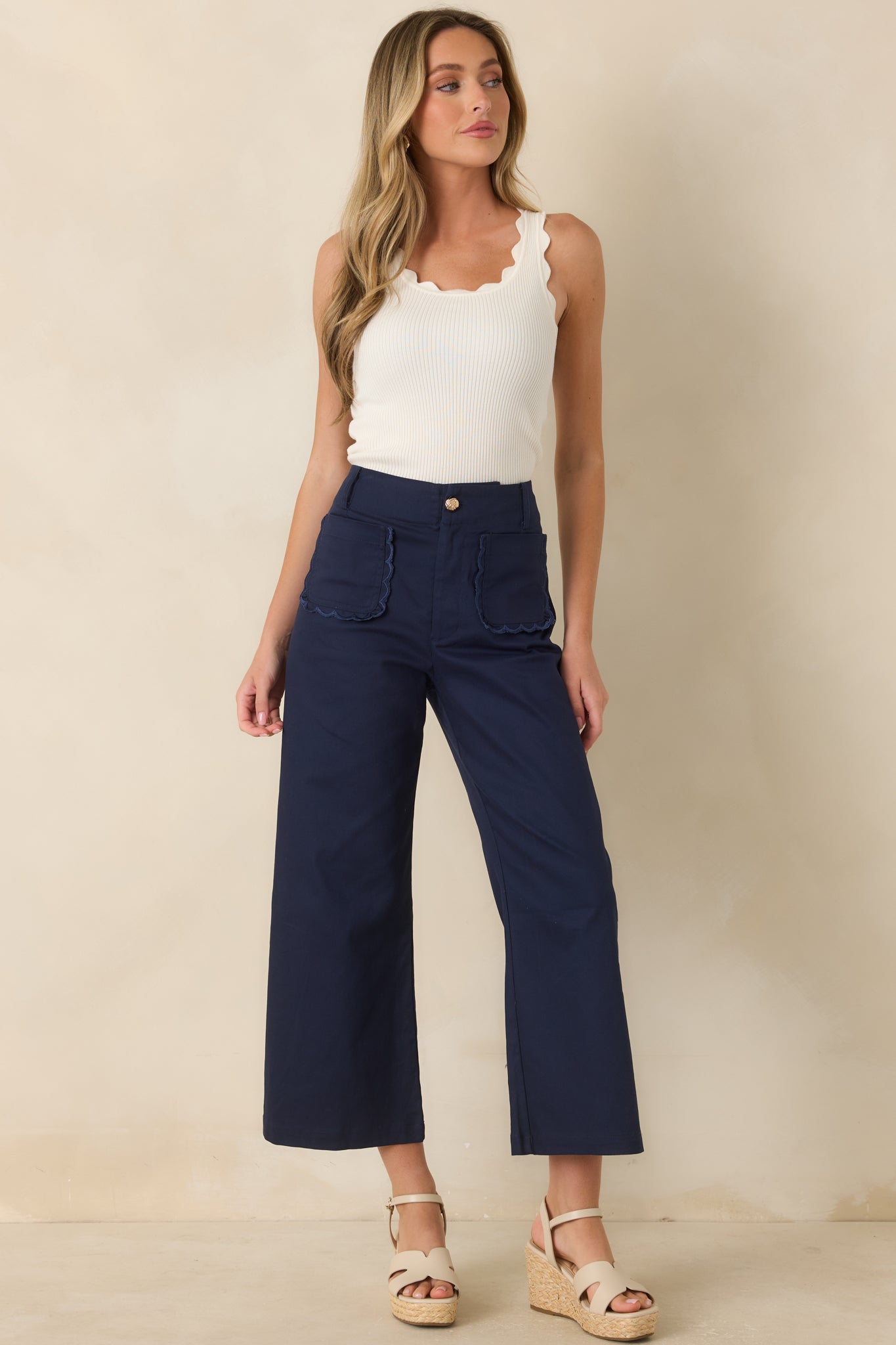 Cropped wide-leg pants highlighting the tailored silhouette, front patch pockets, and elegant feminine accents.