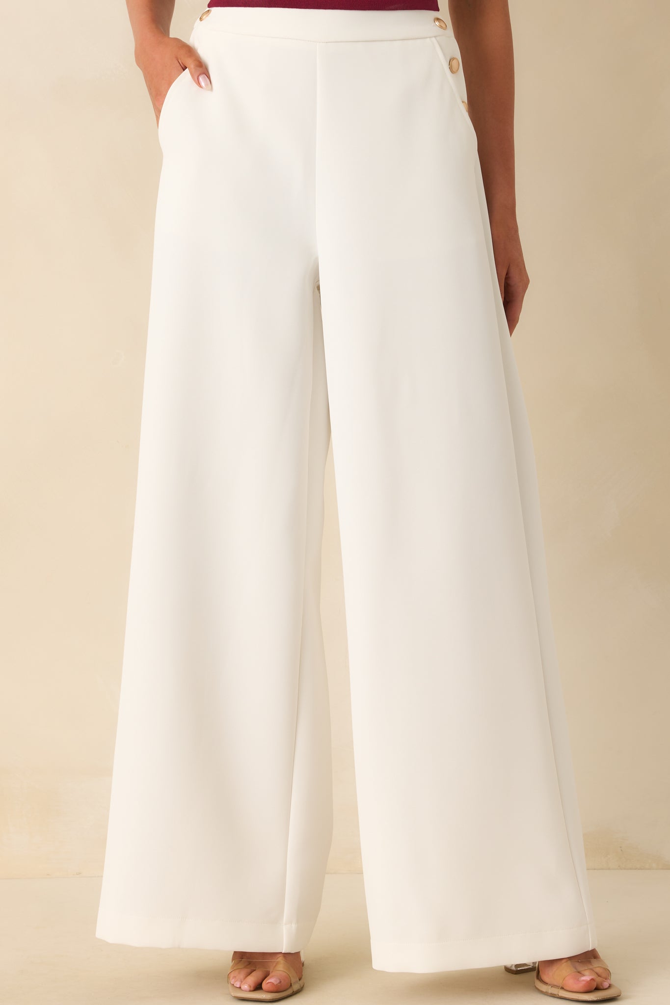 Cropped view focusing on the thick waistband and decorative gold buttons along the front sides.