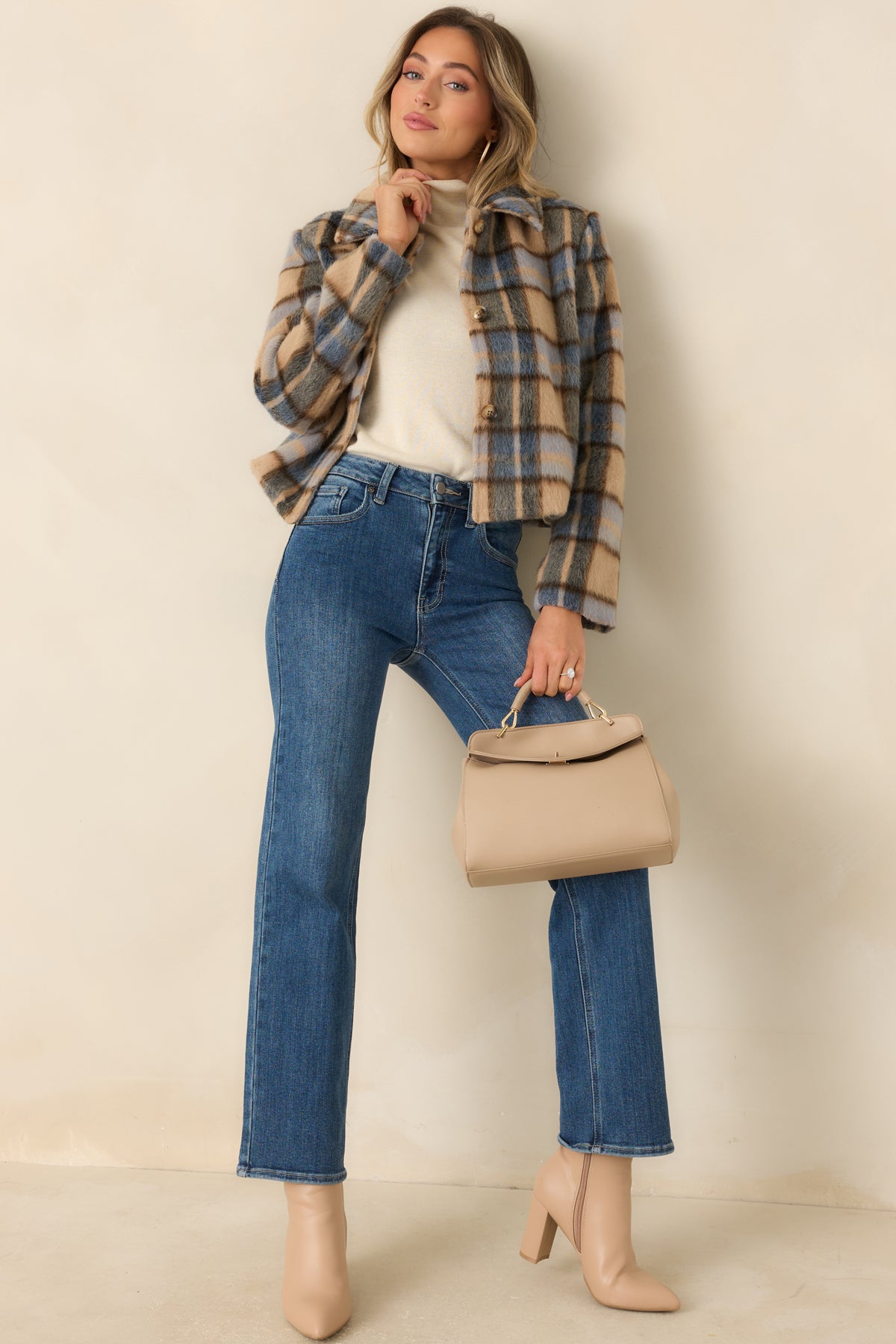 Cropped jacket in warm toffee, muted blue, and charcoal with a pointed collar and tortoiseshell-style buttons.