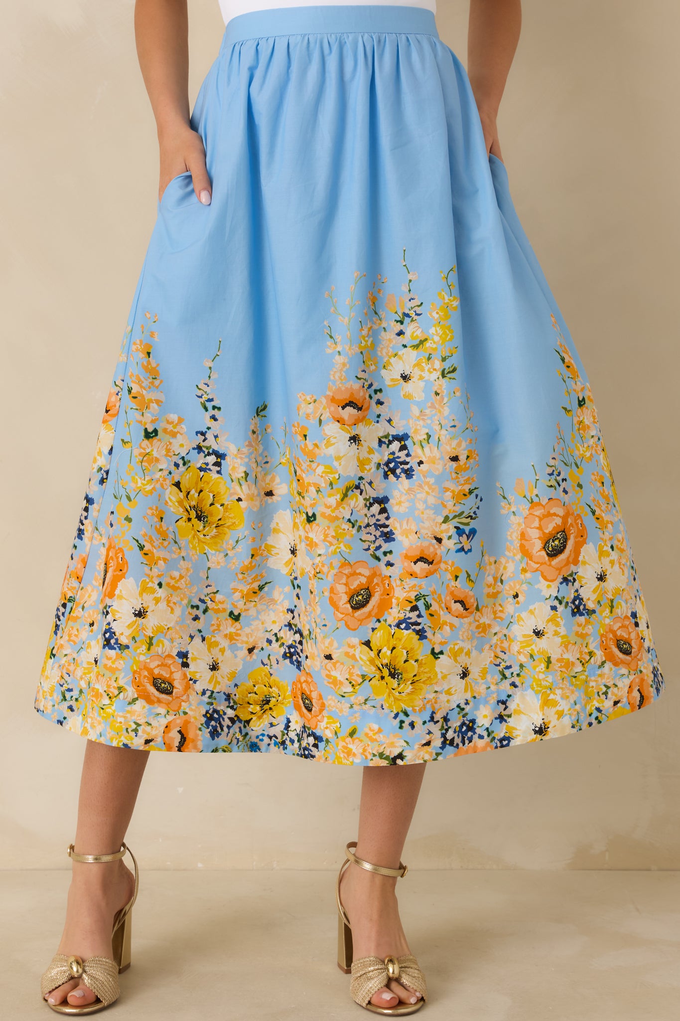 Cropped view of the blue cotton skirt emphasizing the multicolor floral print along the hem.