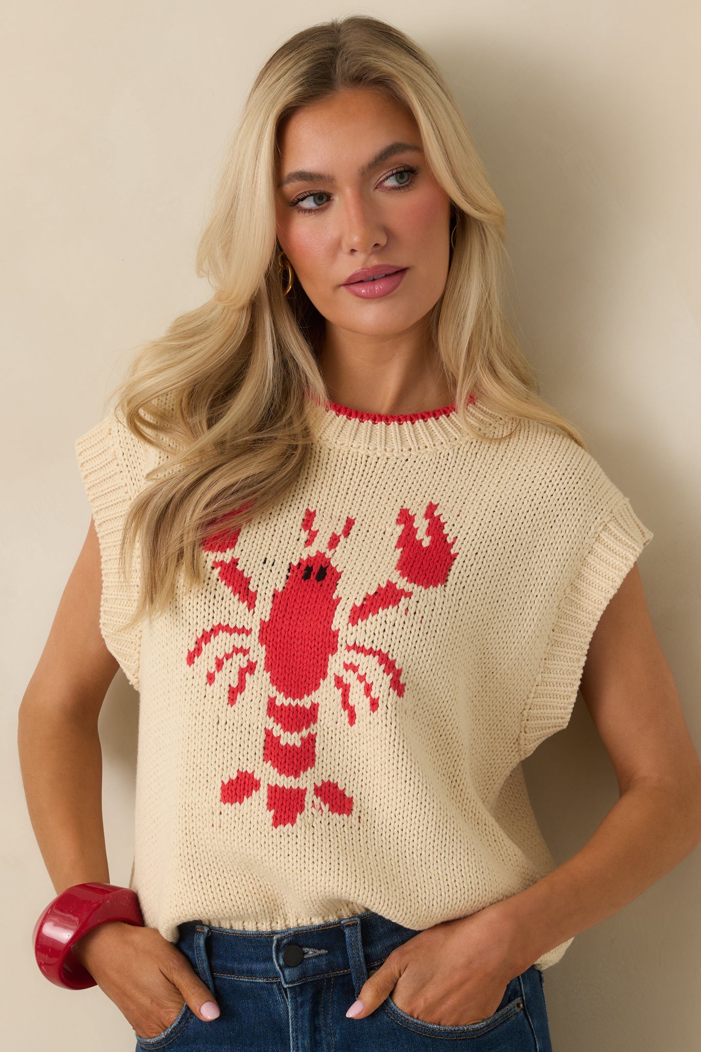 Cropped front view focusing on the crew neckline and ribbed trim of the ivory sleeveless sweater.