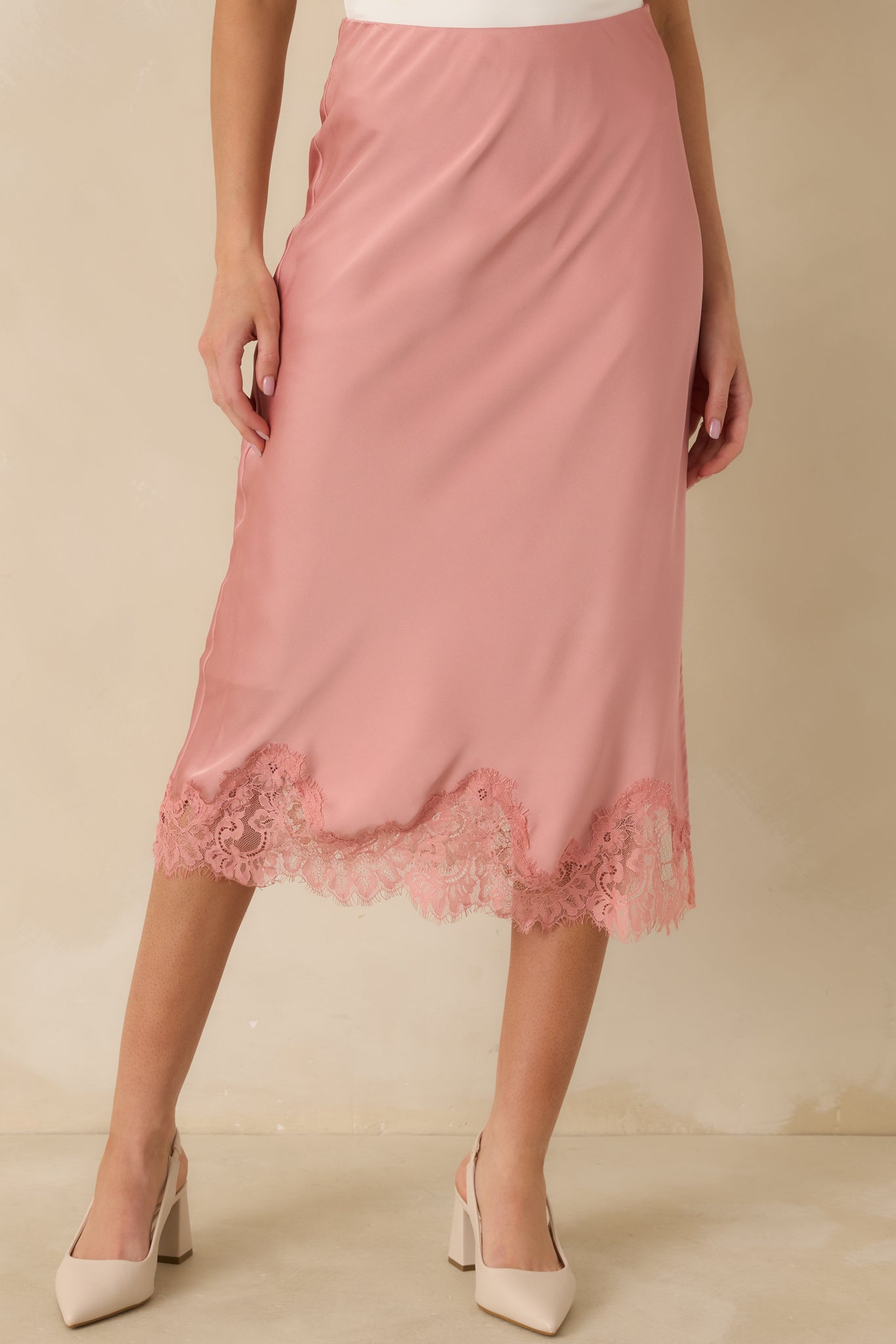 Cropped view of the blush midi skirt focusing on the elastic waistband and sleek satin texture.