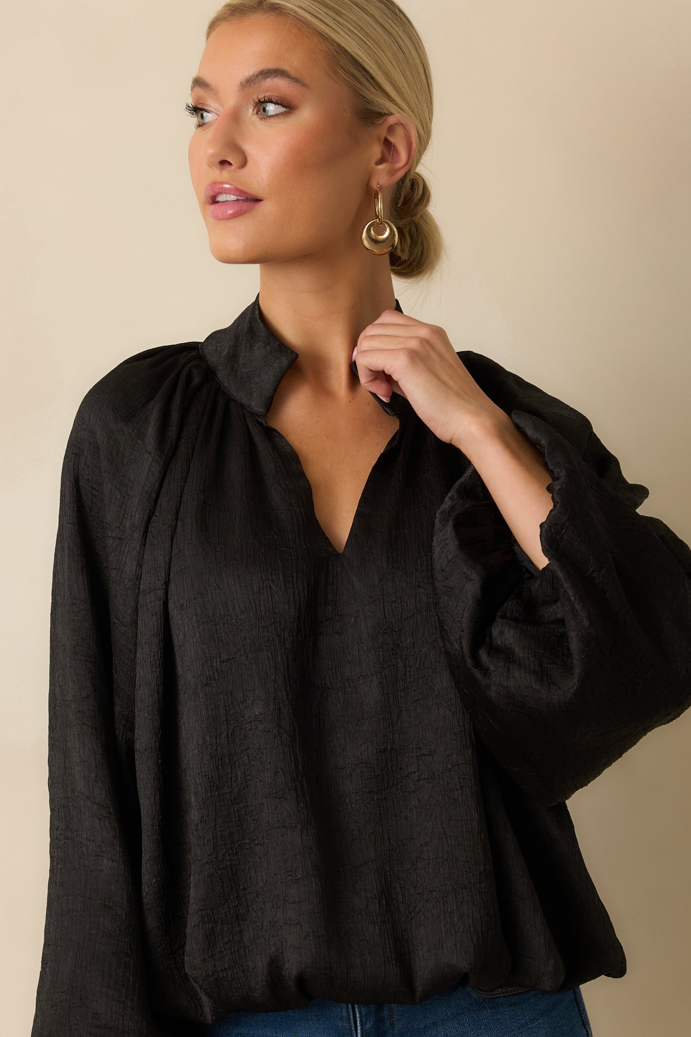 Crop highlighting the gathered cuffs and flow of the long peasant sleeves.