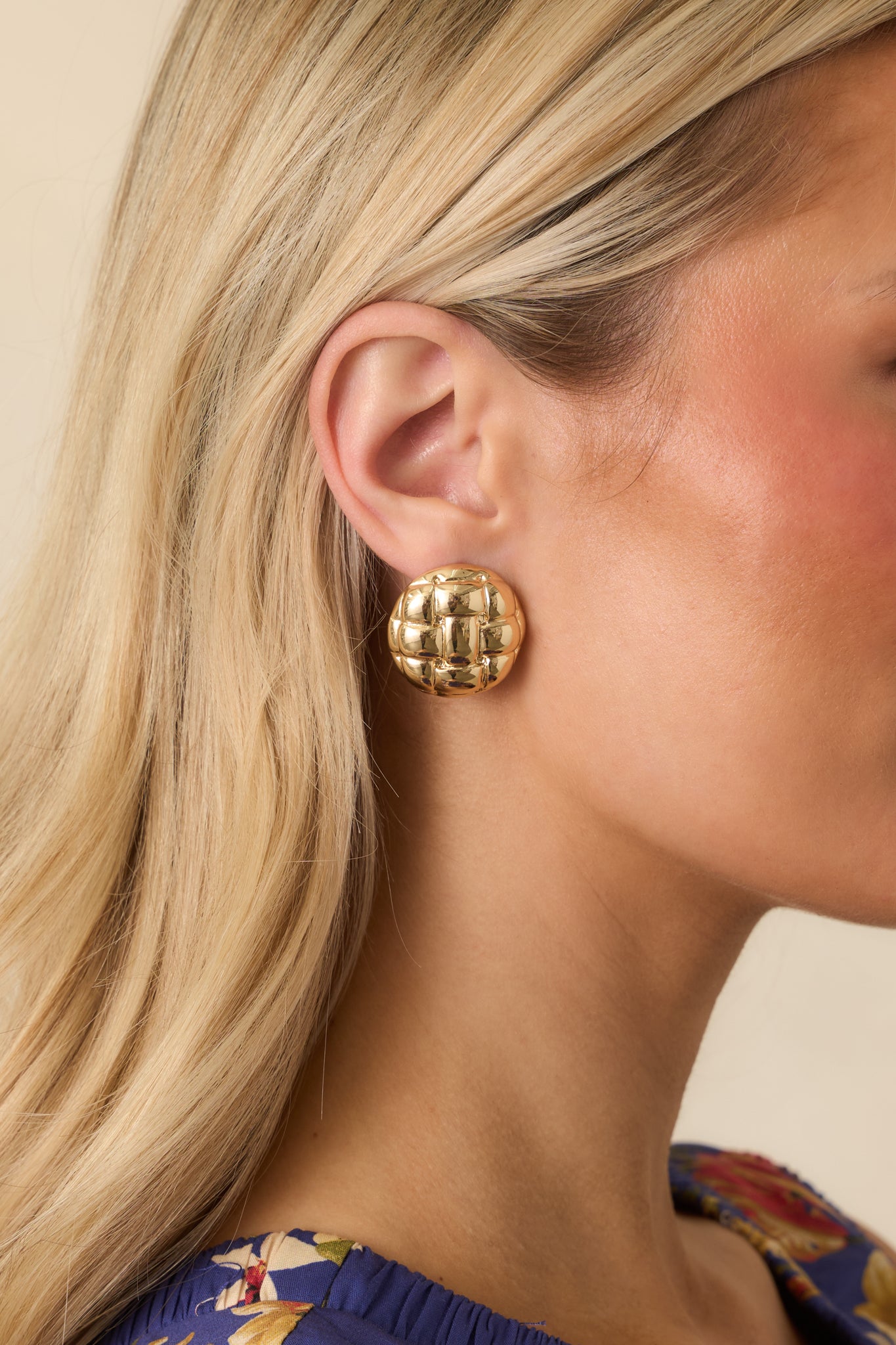 Cropped view of gold dome earrings showing raised woven lattice texture.