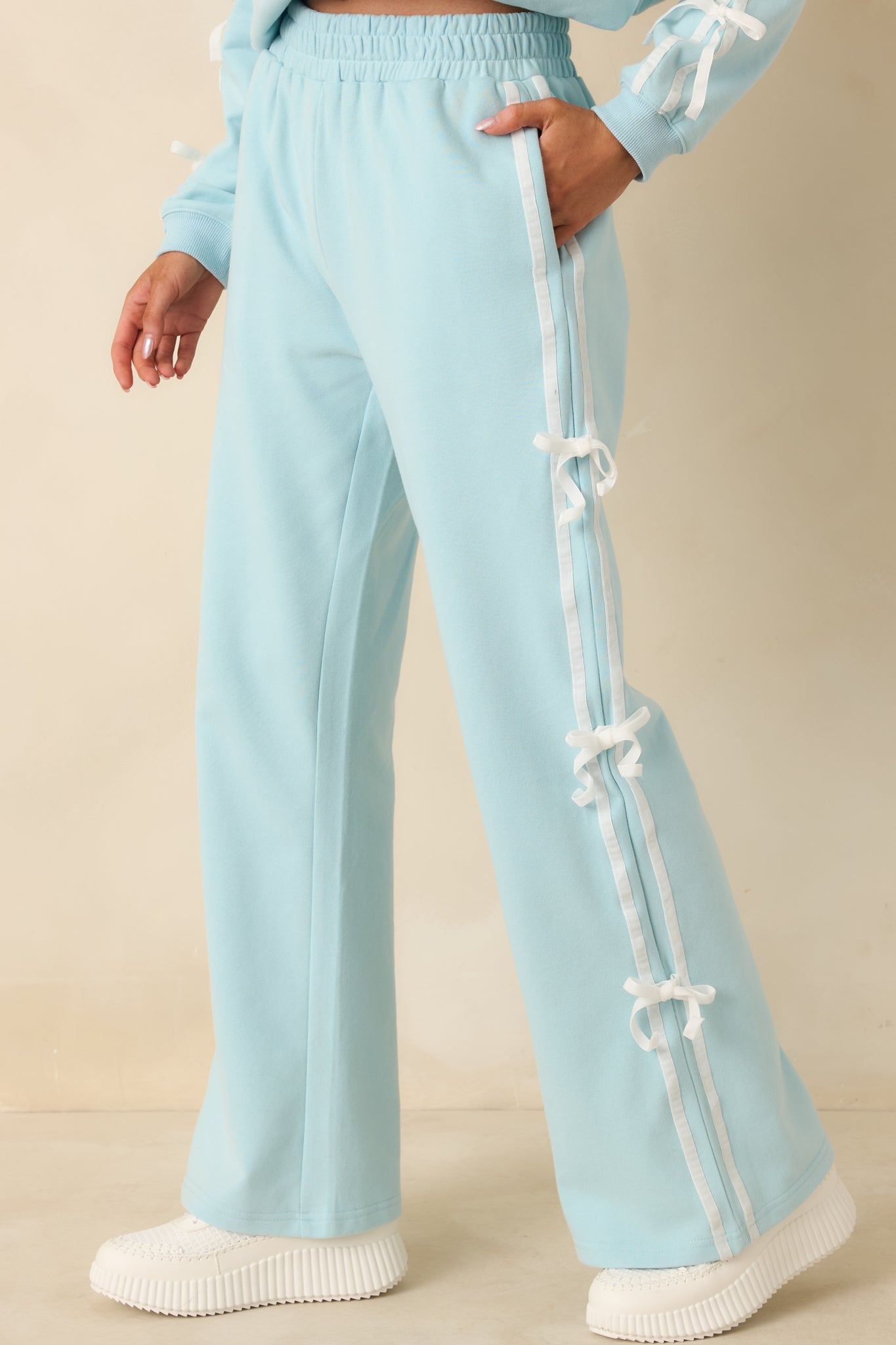 Cropped view highlighting straight-leg silhouette and side embellishments on aqua pants.