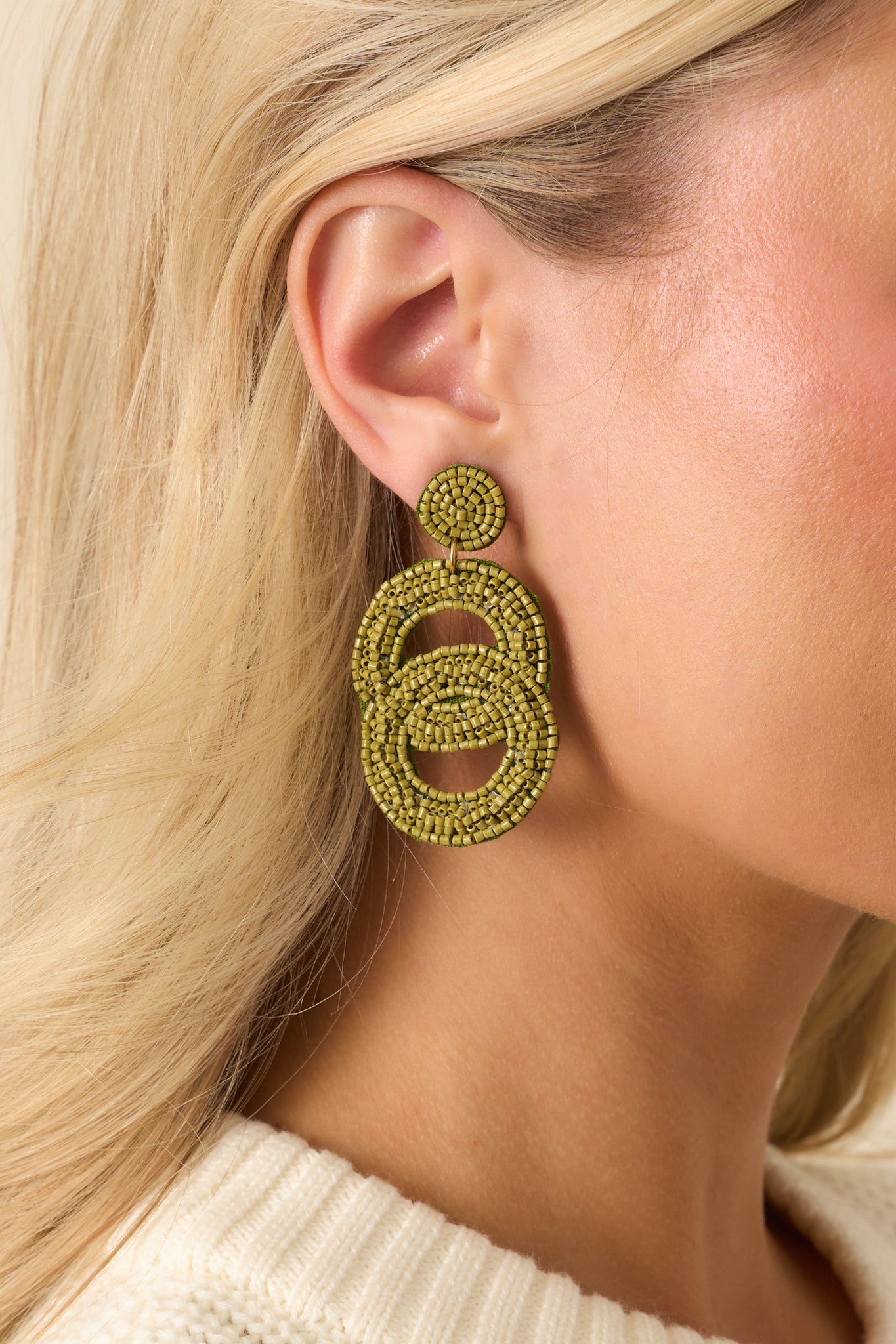 A cropped front view highlighting the circular beaded stud and two interlocking oval drops.