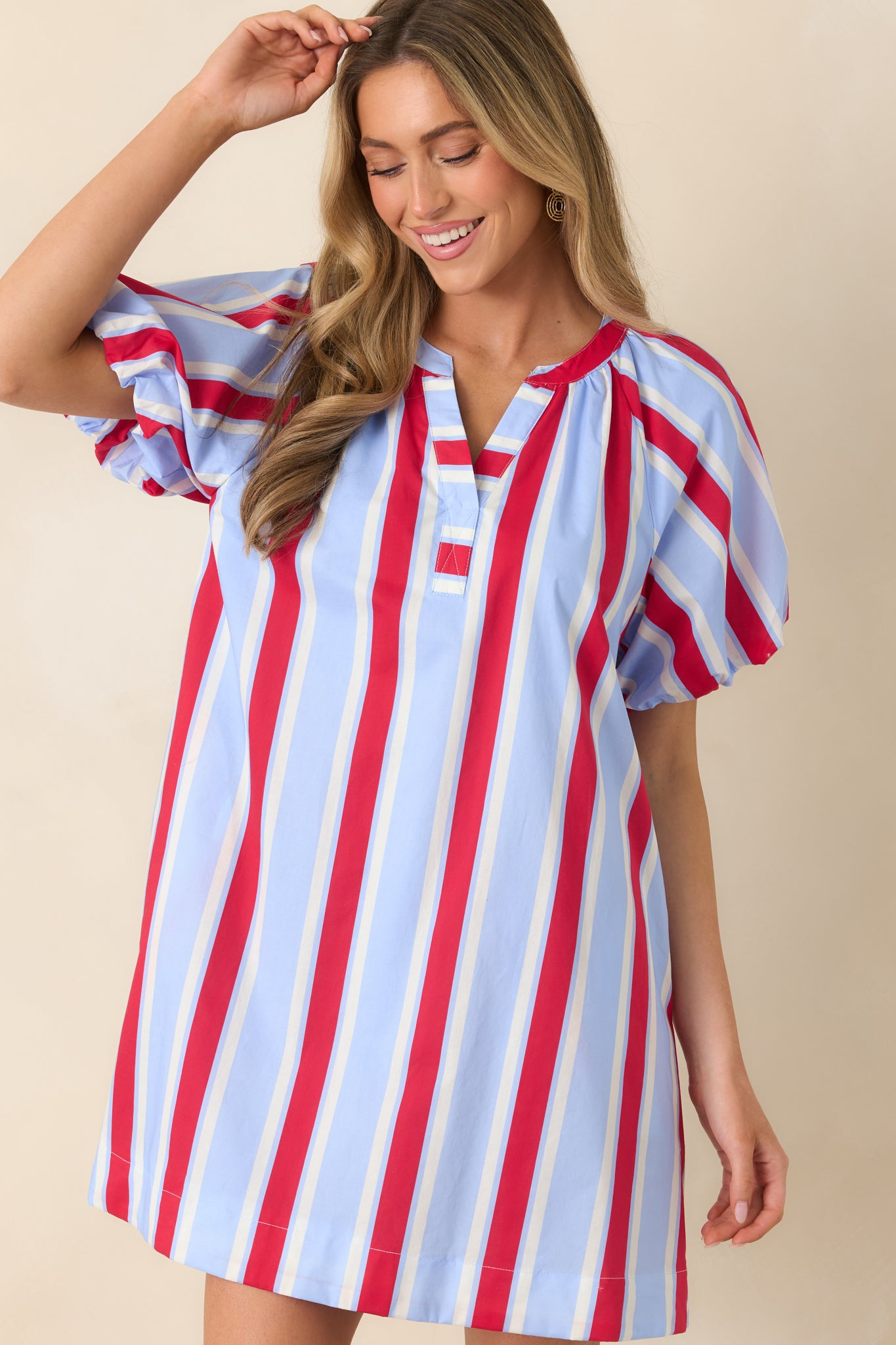 Cropped view highlighting the puff sleeves and playful stripe pattern on the red and blue mini dress