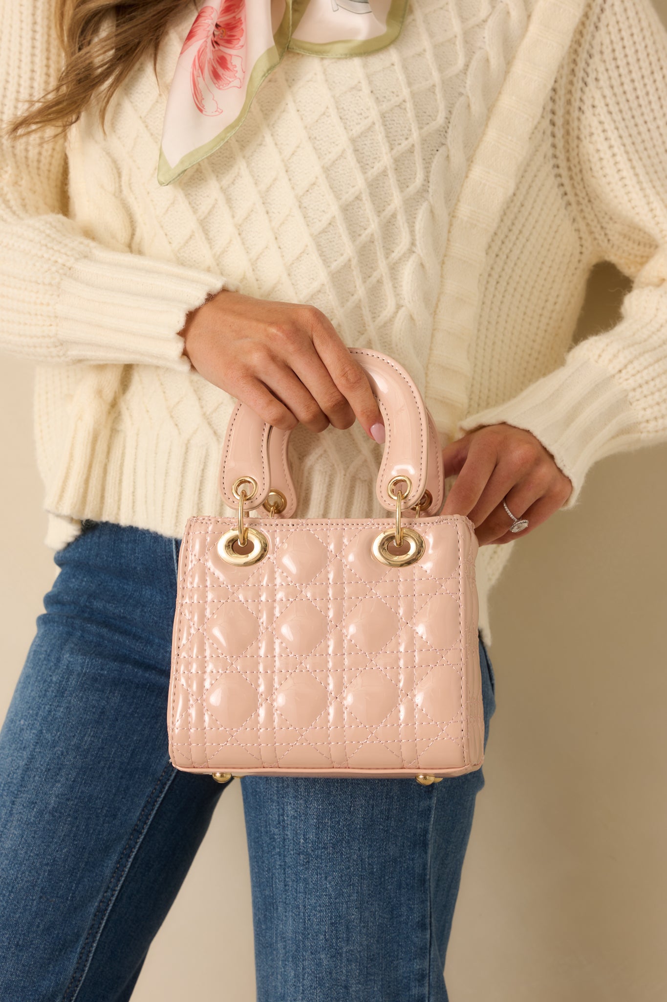 Cropped view highlighting the quilted faux patent leather texture and structured shape of the pink handbag.