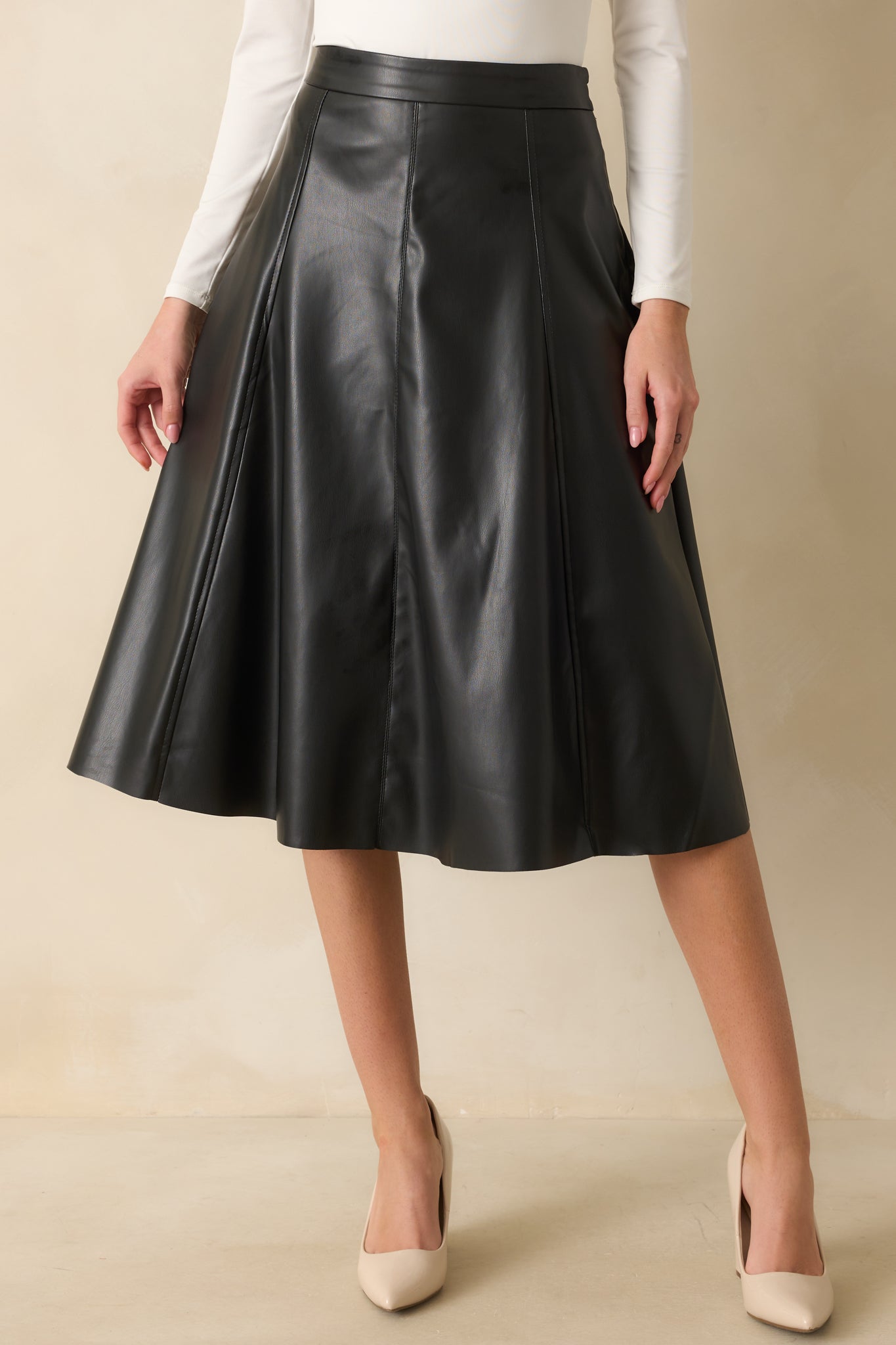 Another cropped shot emphasizing the waist and faux leather texture of the midi skirt.