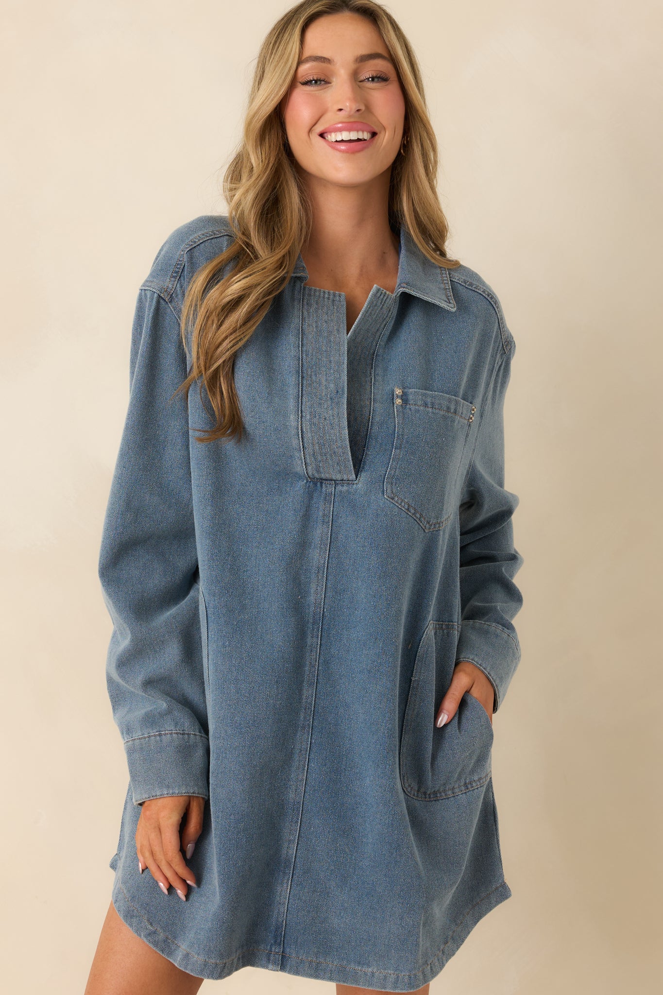 Cropped front view of the denim mini dress focusing on the collar, button placket, and cuffed sleeve details.