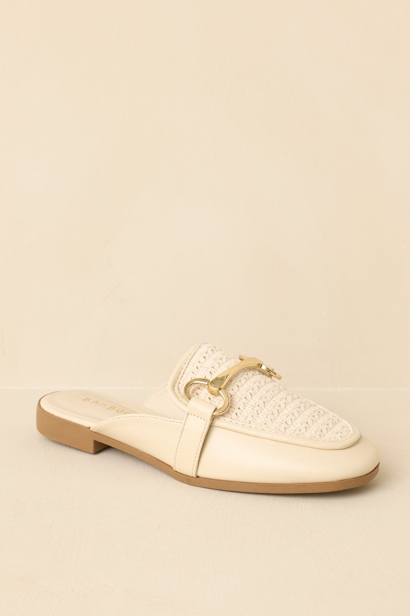 Cropped front-side view of ivory mule loafers showcasing the dimensional woven design and minimal profile.