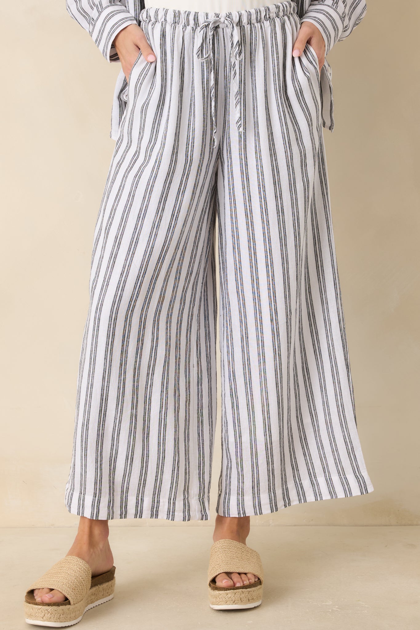 Cropped view of striped pants focusing on the high-rise elastic waistband and adjustable drawcord.