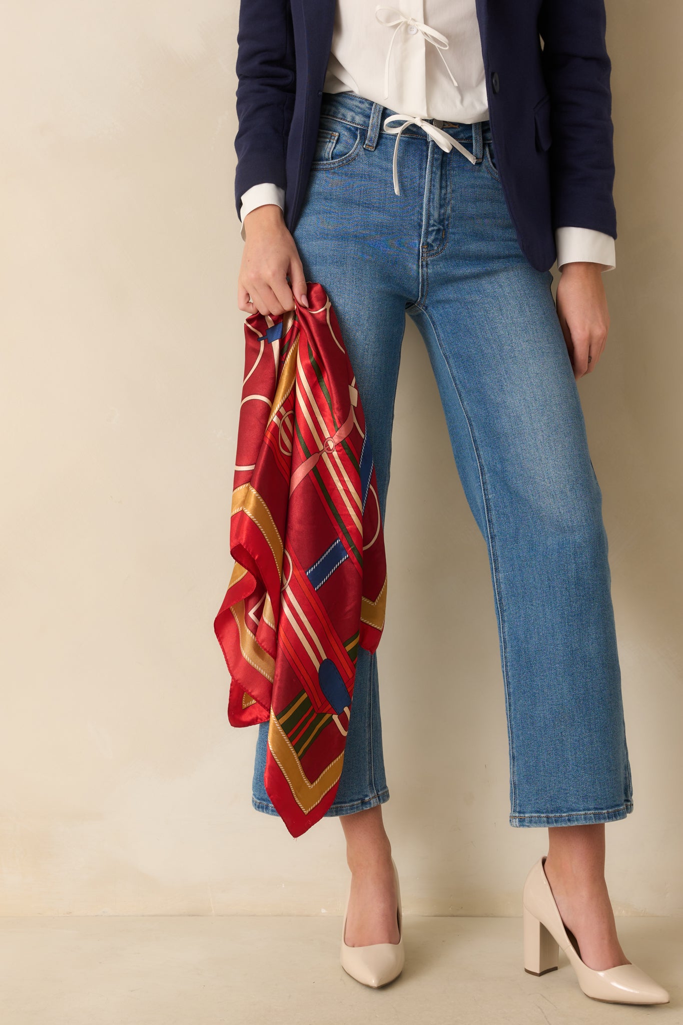 A cropped view of the red satin scarf, emphasizing the glossy texture and part of the multicolored print.
