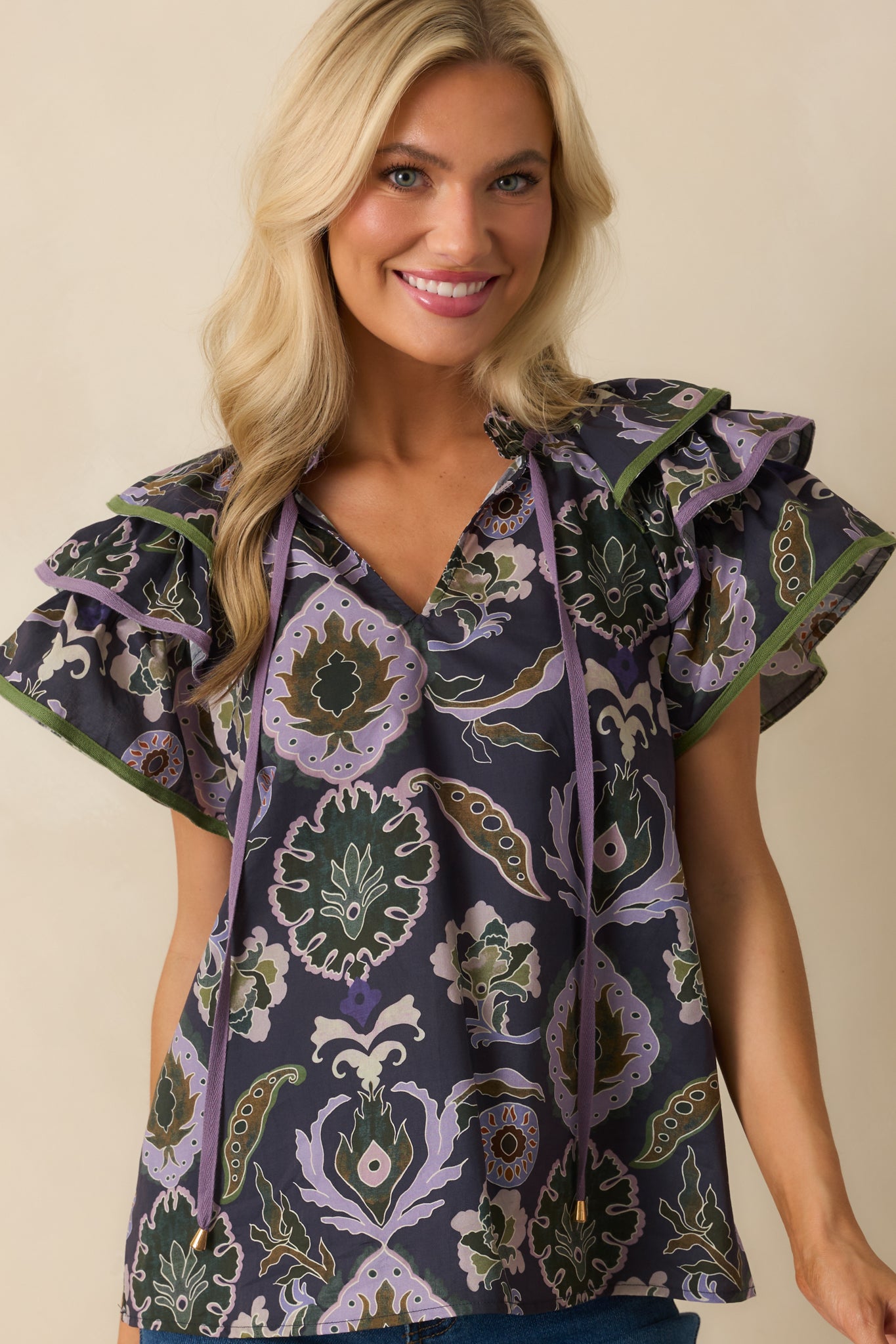 Cropped view of short sleeves, showing ruffle detail and print pattern.