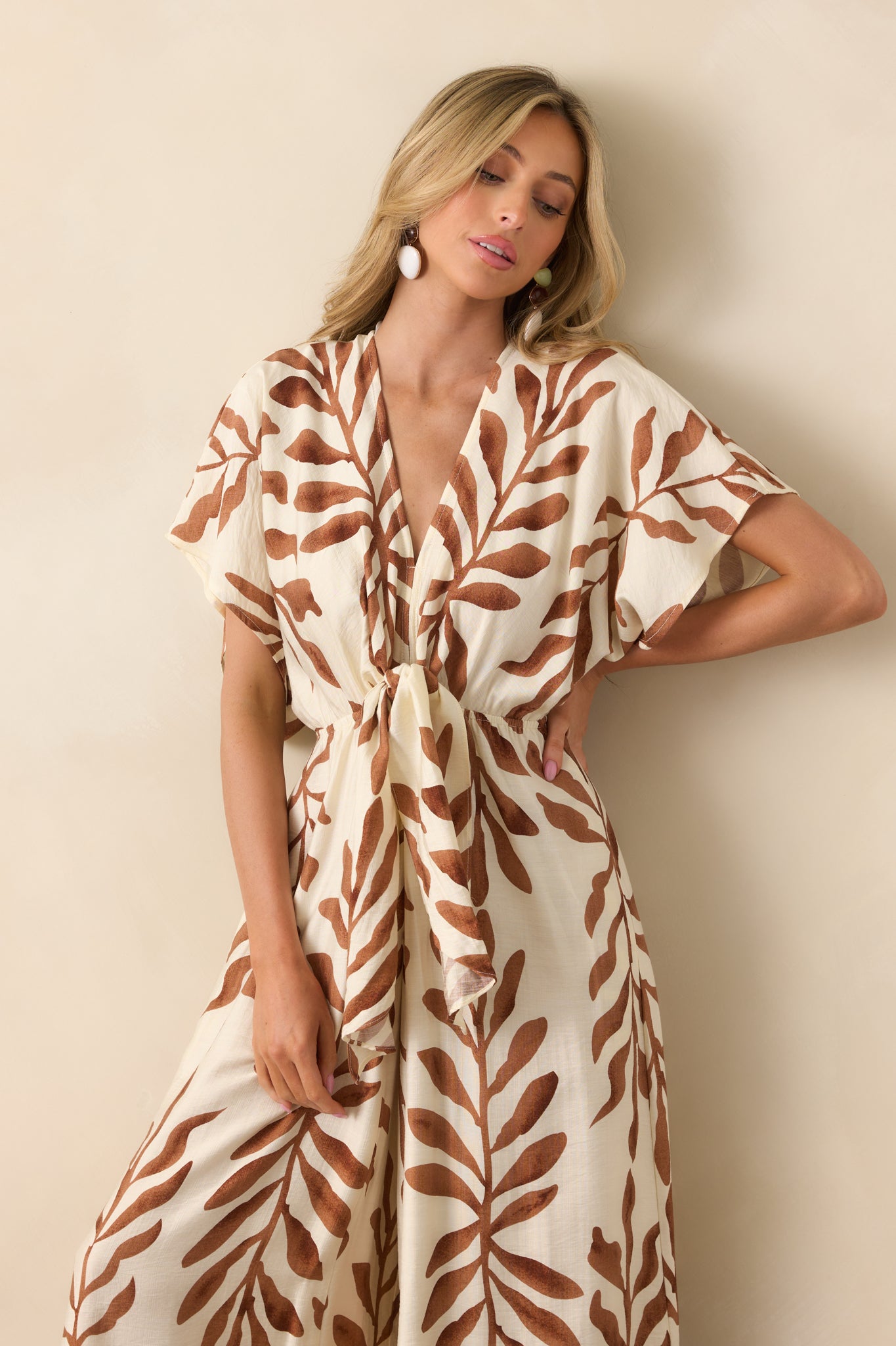 Cropped view of the upper bodice showing the v-neckline, self-tie front knot, and botanical print detail.