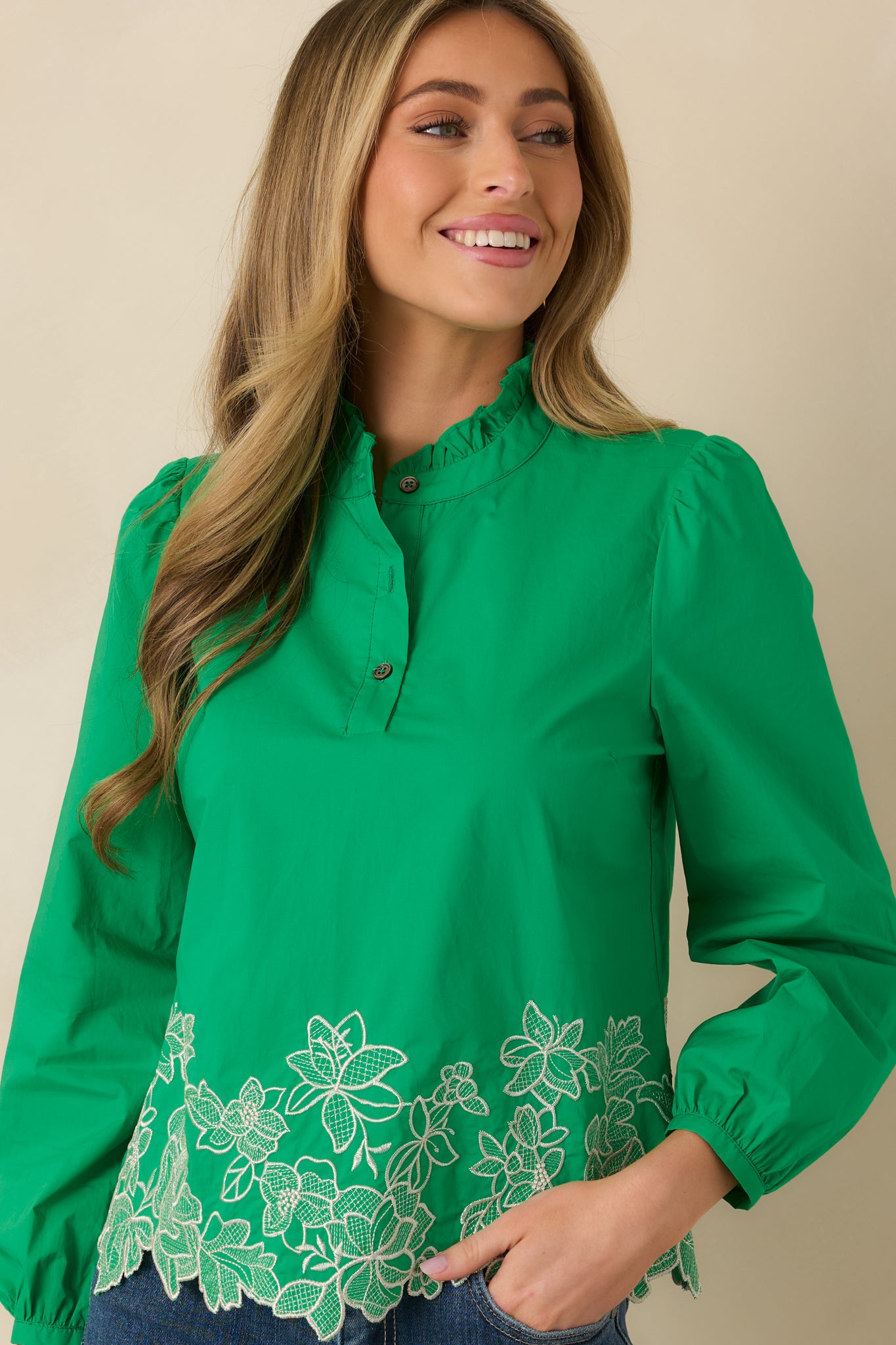 Detailed cropped view of the top showcasing subtle sleeve volume, gathered neckline, and decorative embroidery.
