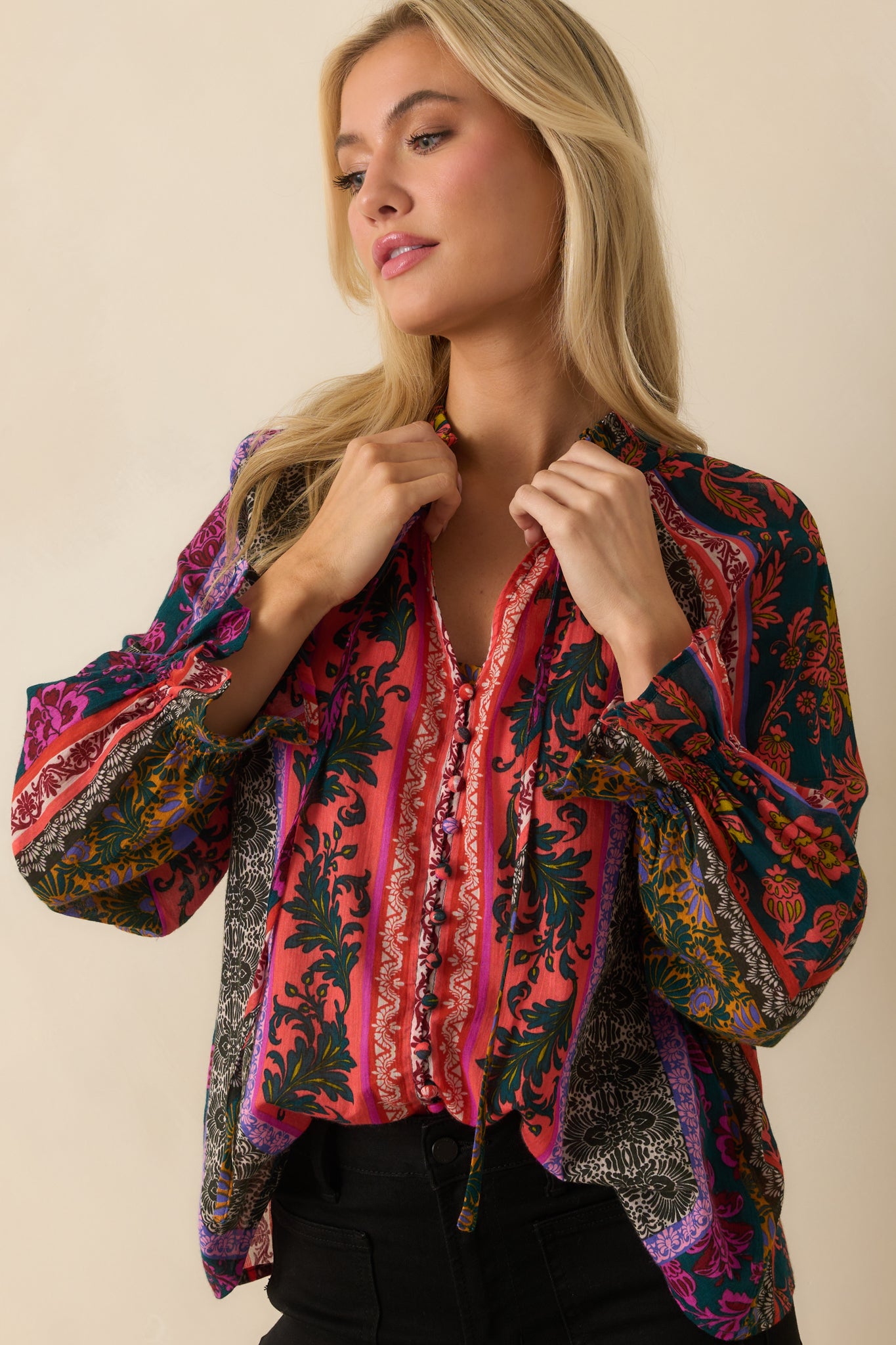 A cropped waist-up view focusing on the notched V-neckline and patchwork print.