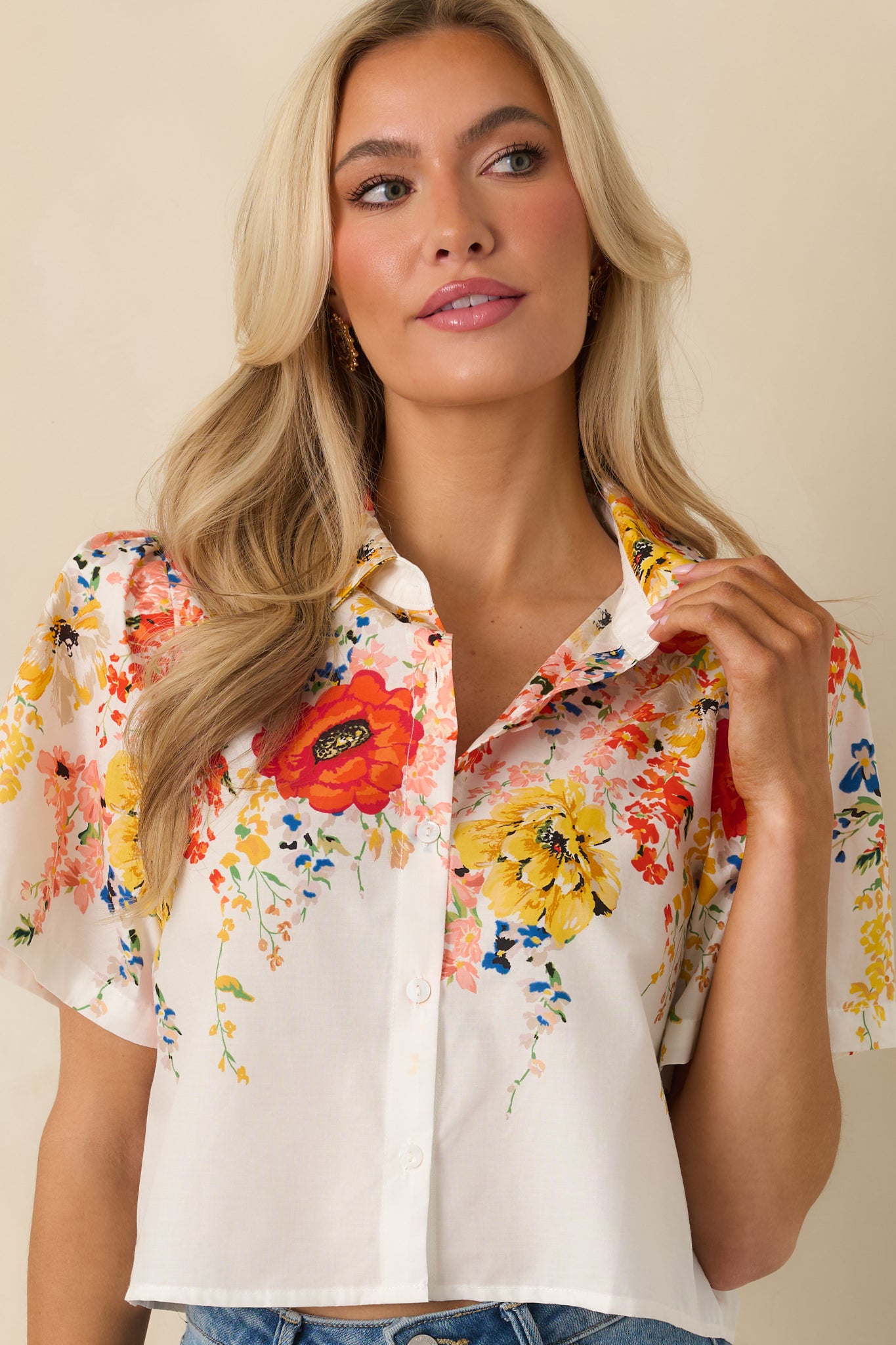 Cropped view of the white top emphasizing the multicolor floral print and lightweight cotton texture.