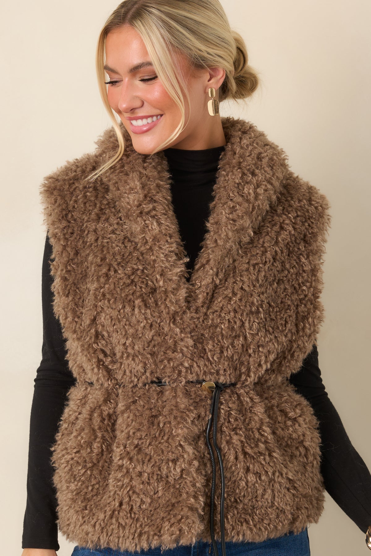 Curly faux fur vest showcasing the oversized collar, plush texture, and functional pocket detailing.
