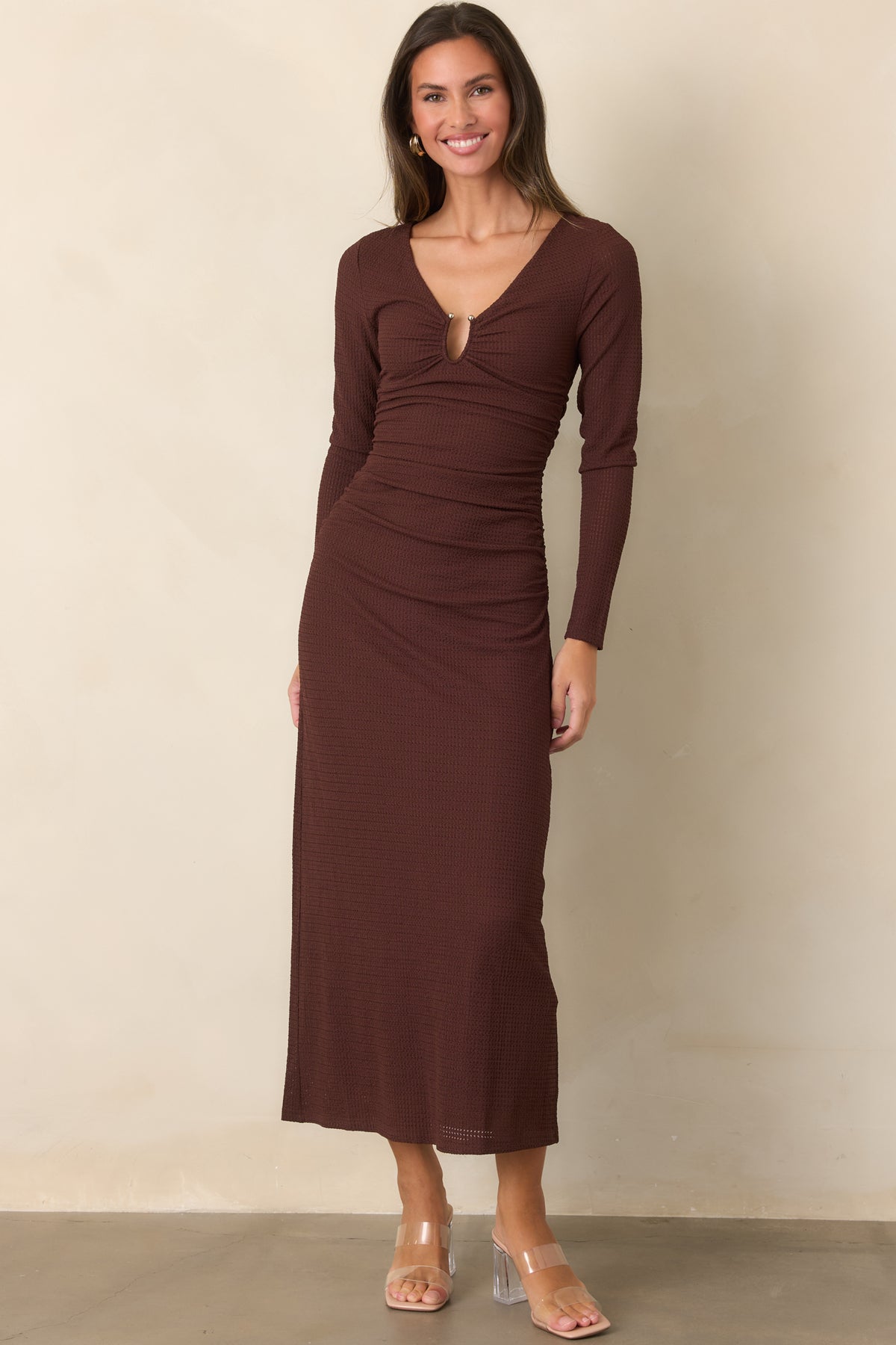 Curve-skimming dress features gathered ruching at the bodice and waist, transitioning into a relaxed flowing midi skirt.