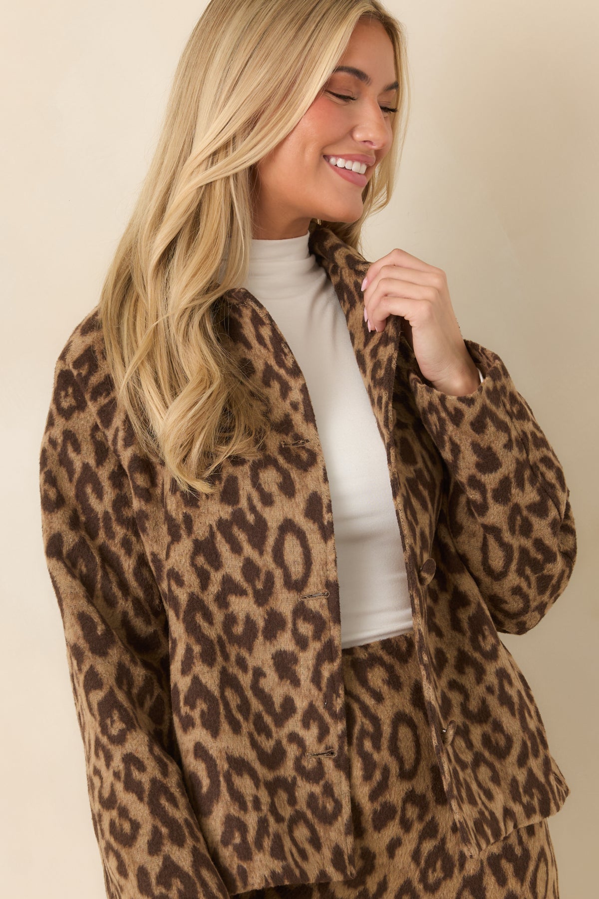 Dark brown leopard spots contrast with the warm camel background across the jacket's brushed fabric.
