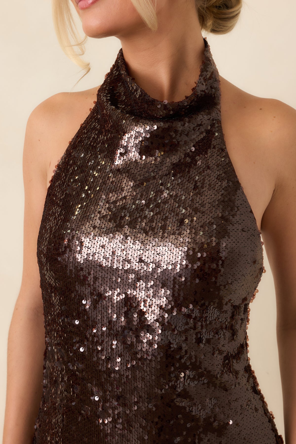 Close-up of the dark brown sequins and softly draped fabric at the dress neckline.