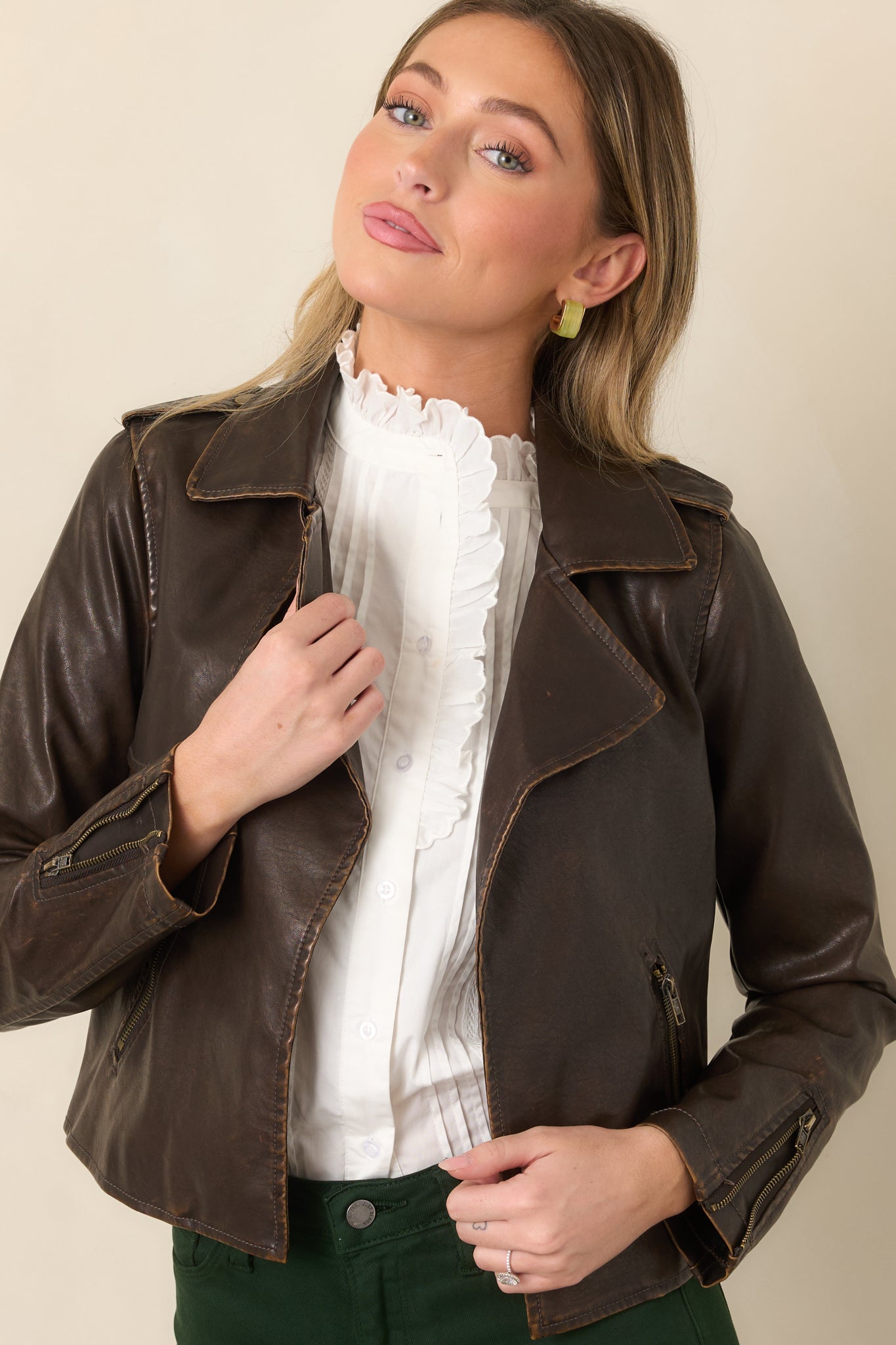 Close view of the dark brown jacket highlighting the wide notched lapels, open front, and smooth faux leather texture.