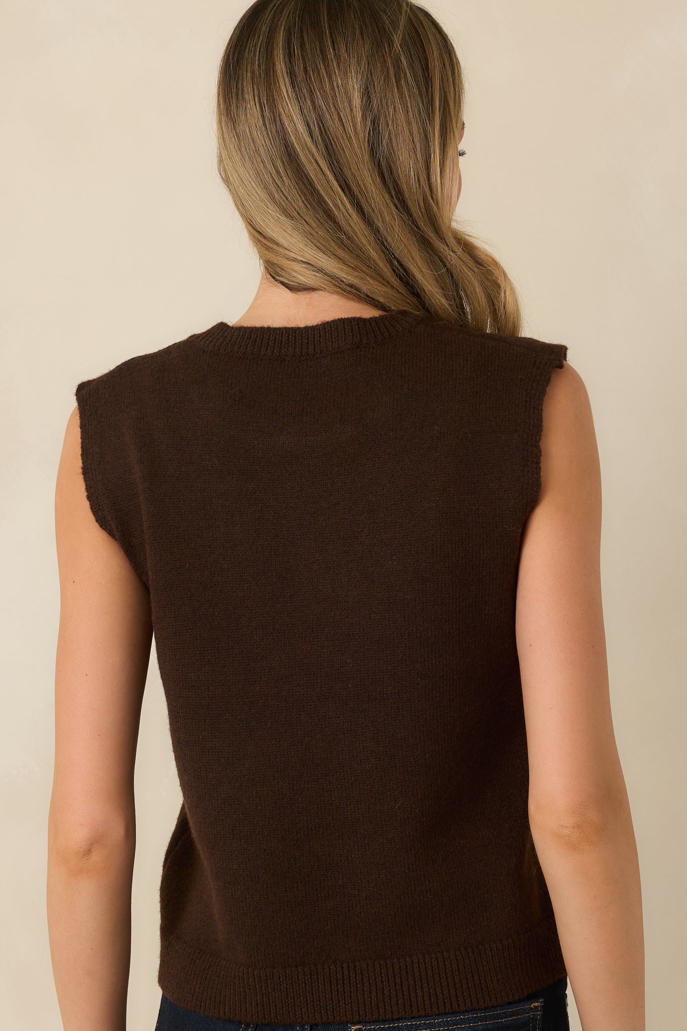 Back view of dark chocolate sleeveless knit top featuring extended shoulders, a straight fit, and ribbed hemline.