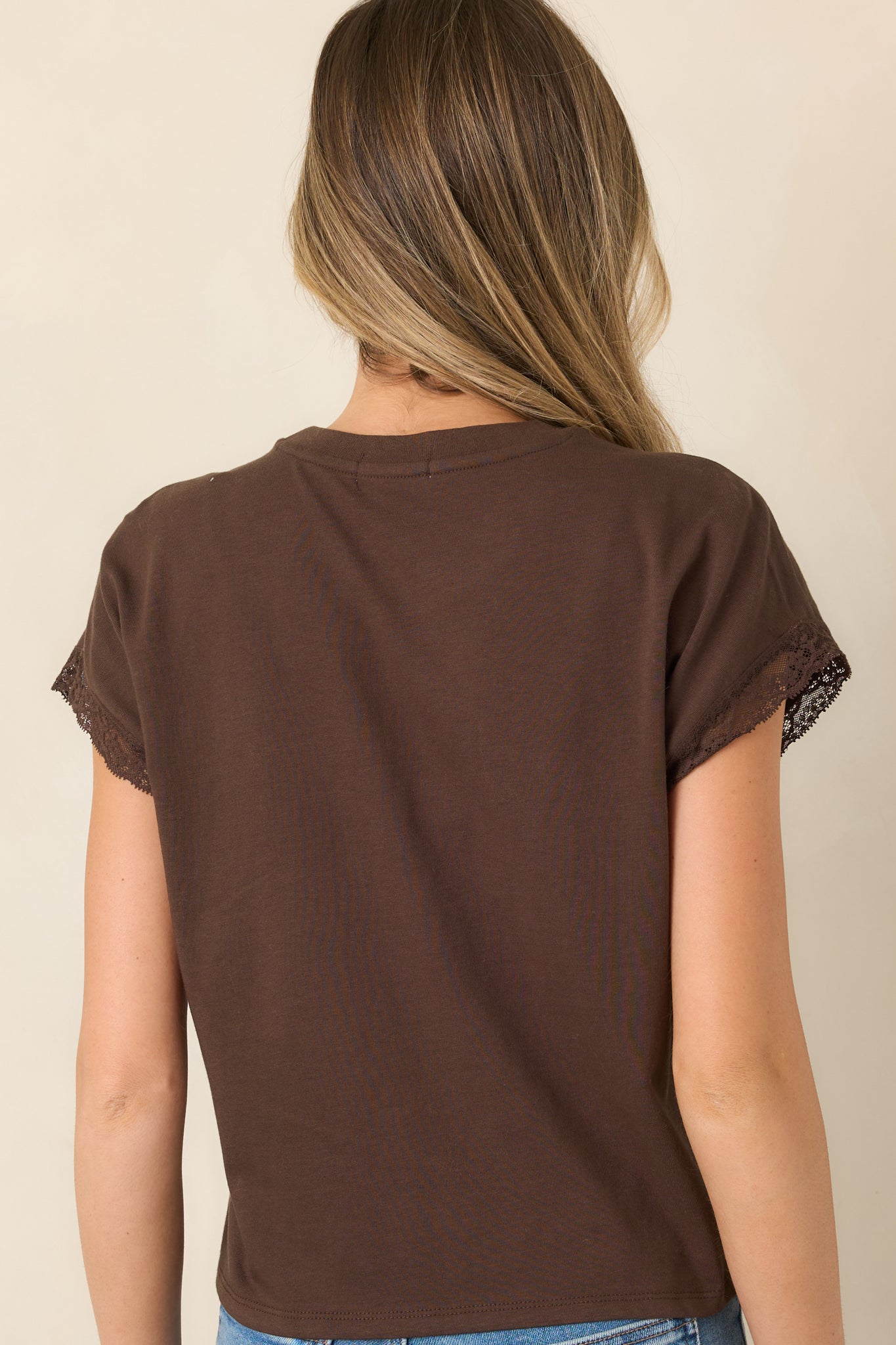 Rear view of the dark chocolate top showcasing its relaxed silhouette, slightly cropped length, and lace-trimmed cap sleeves.