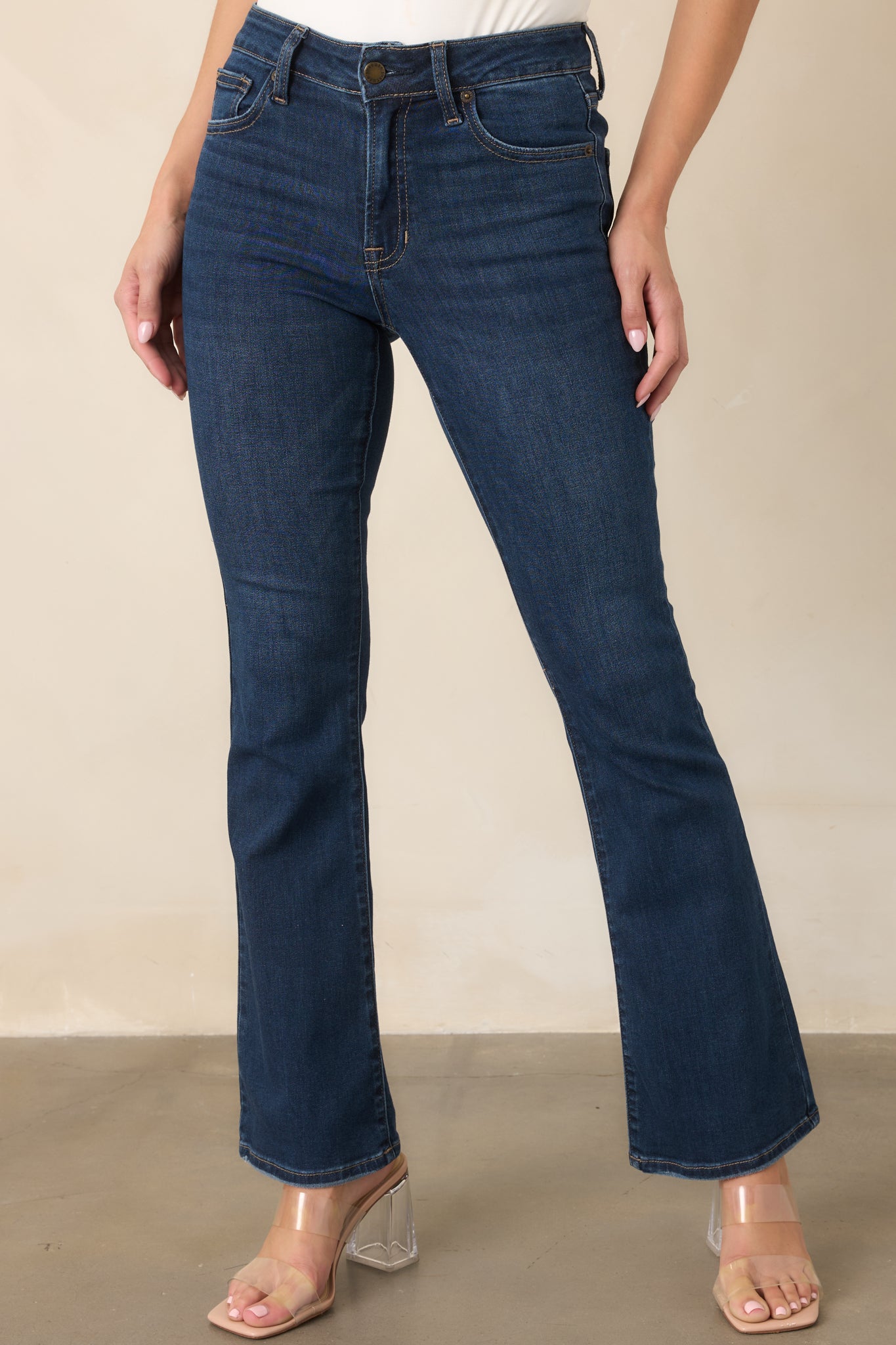 Close view of the dark denim showcasing the fitted hip and thigh construction, five-pocket design, and defined contrast stitching.