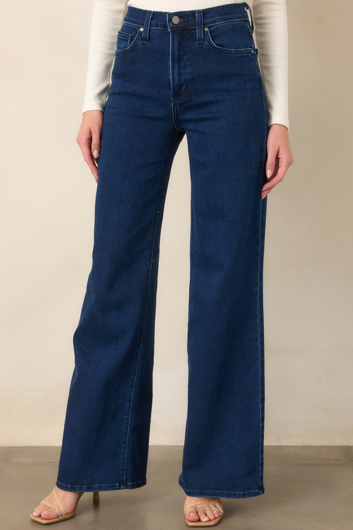 Dark denim jeans showcasing the functional front pockets and smooth wide-leg construction through the upper portion.