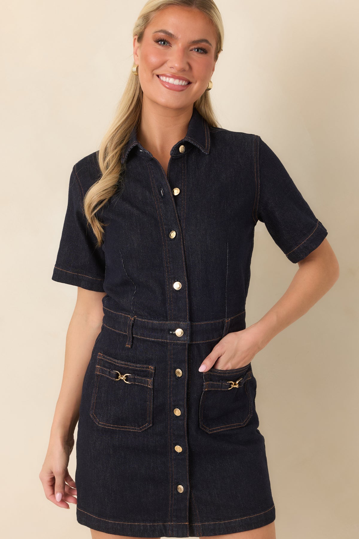 Gold-tone hardware accents the full button-front closure of the dark denim mini dress.