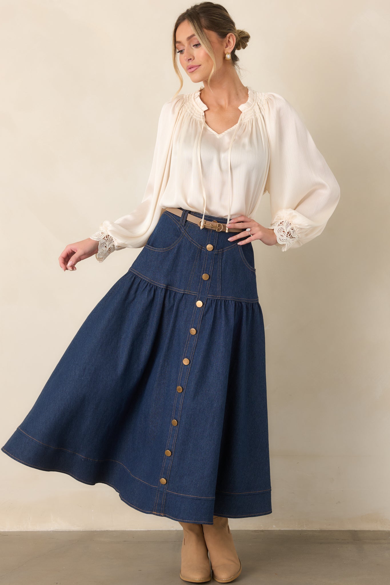 Dark denim maxi skirt featuring a structured waistband, contrast topstitching, front pockets, and a graceful flared shape.