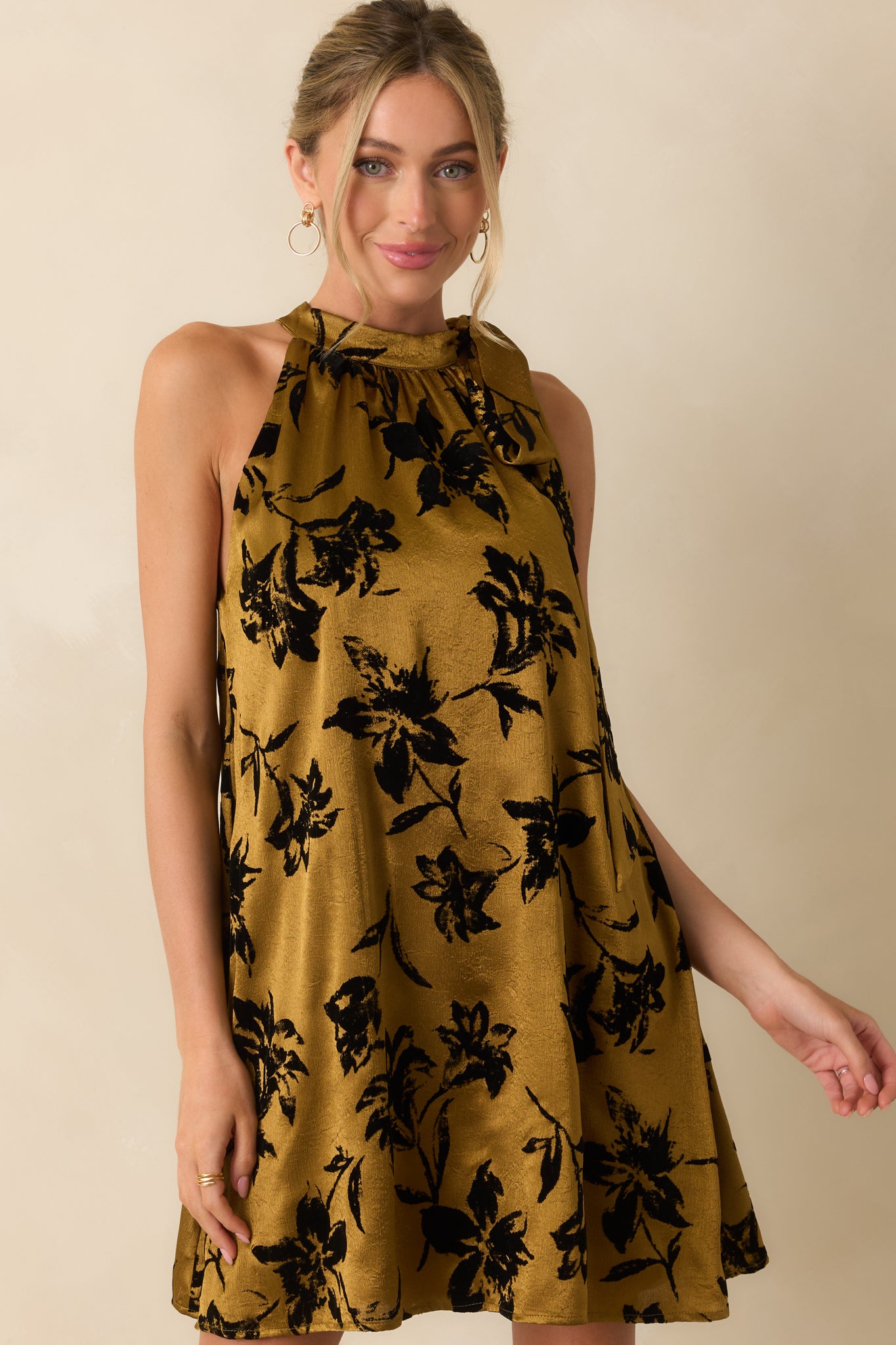 Dark gold satin fabric with visible floral velvet texture and softly structured shape.