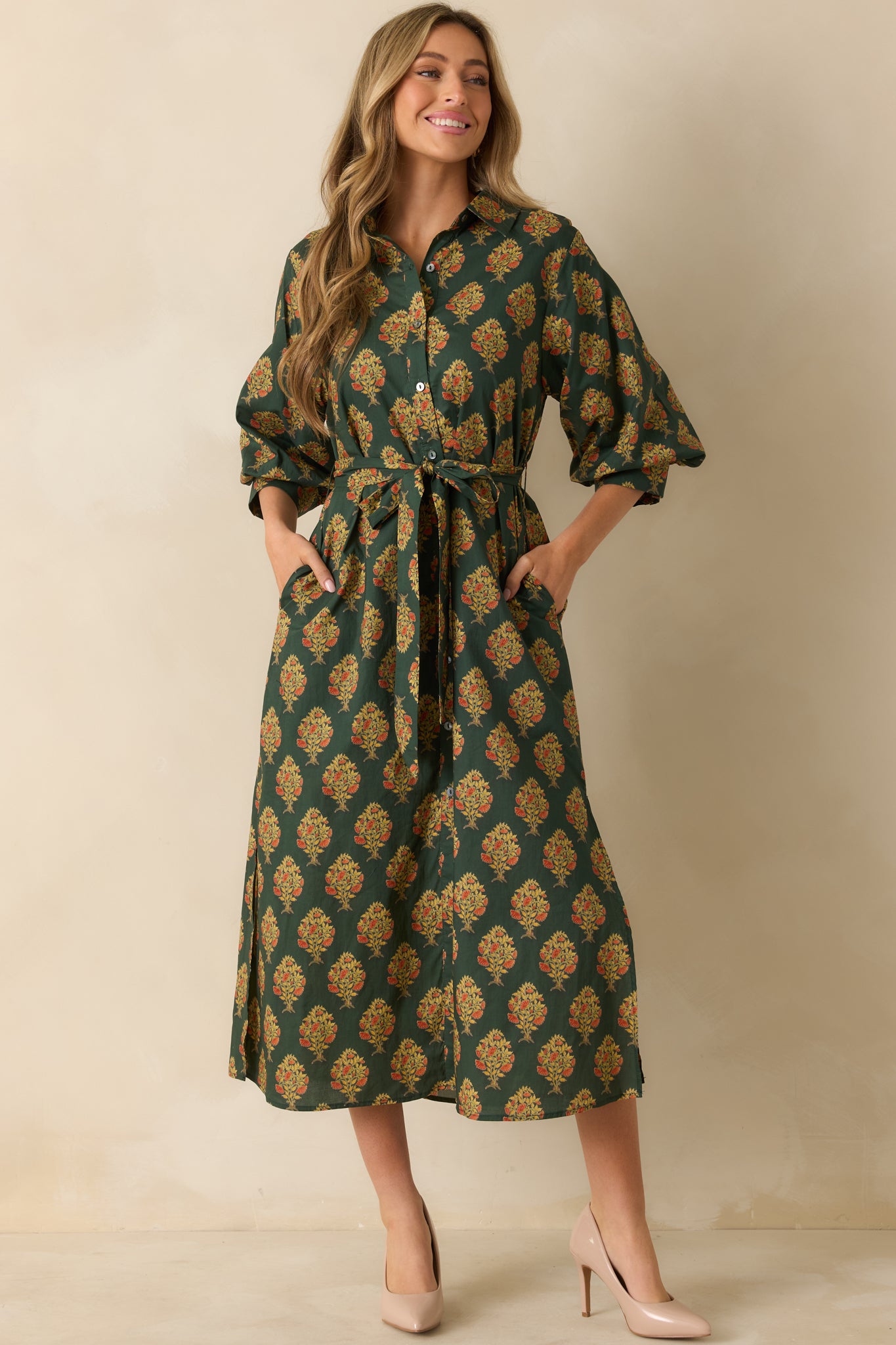 Dark green floral block print maxi dress with collared neckline, button-down front, and half sleeves with buttoned cuffs.