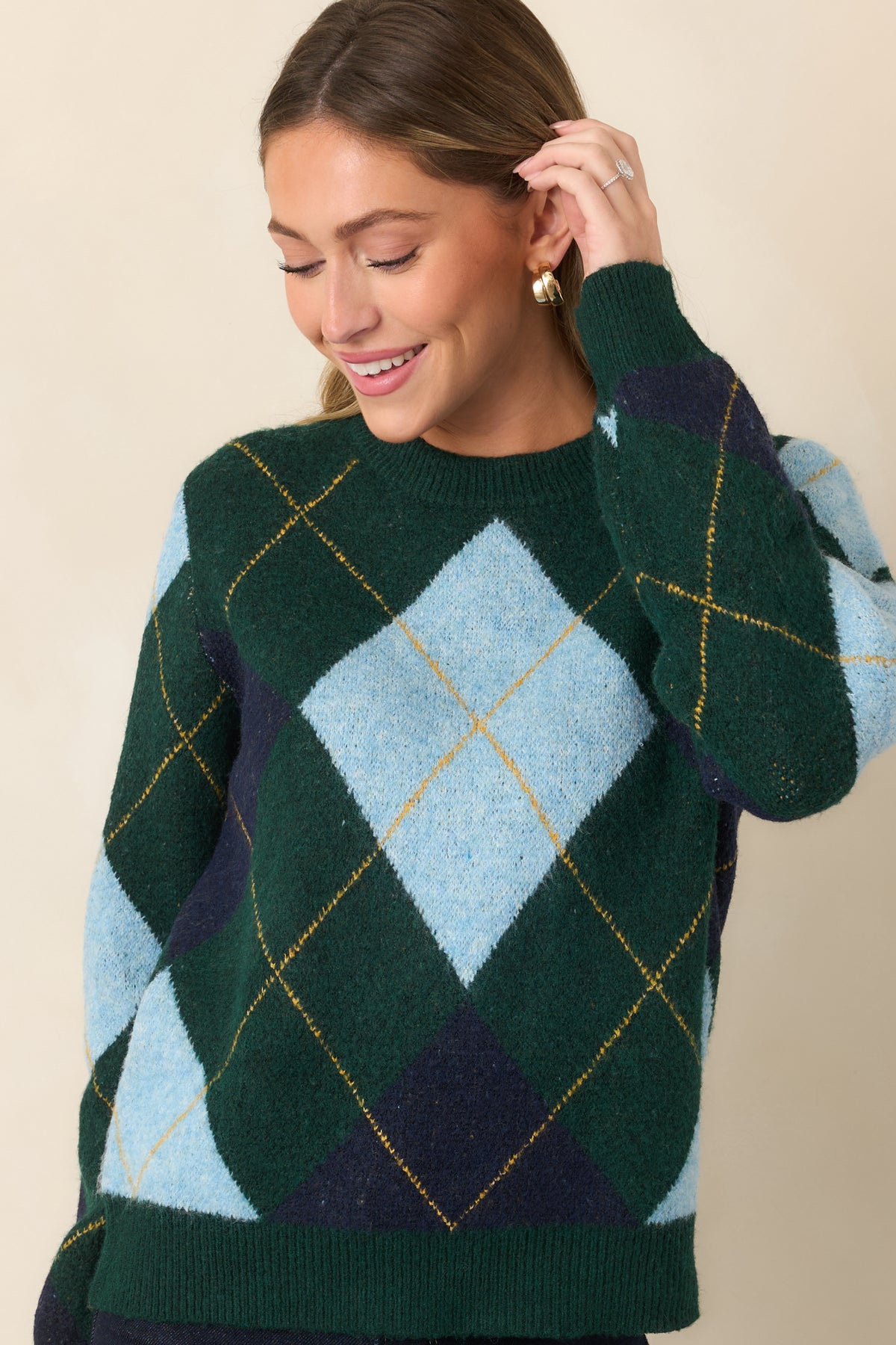 Dark green patterned sweater featuring crisp geometric diamonds in blue tones, subtle golden detailing, and a comfortable relaxed construction.