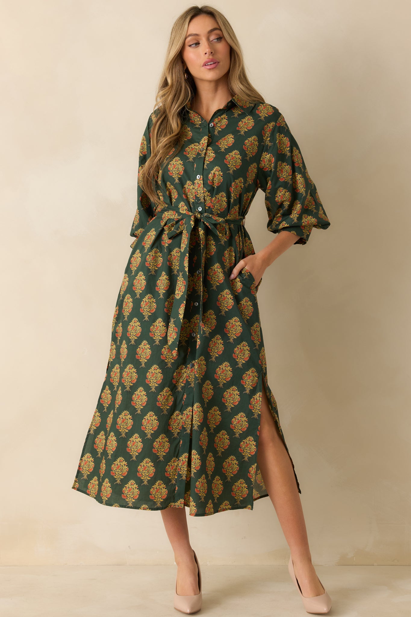 Dark green maxi dress highlighting the flowing silhouette, block floral print, and structured collar.