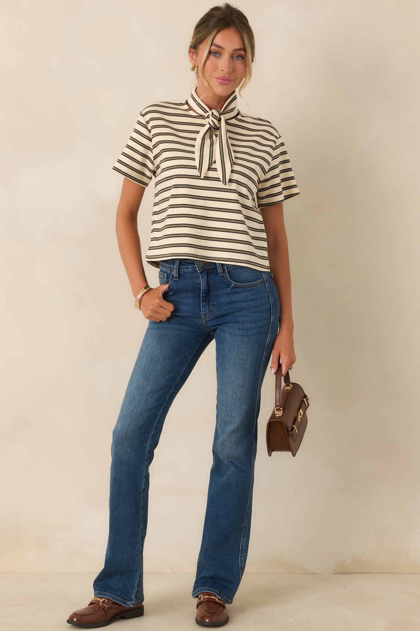 Dark indigo high rise bootcut jeans with subtle fading and whiskering, fitted hips and thighs, and a classic five-pocket design.