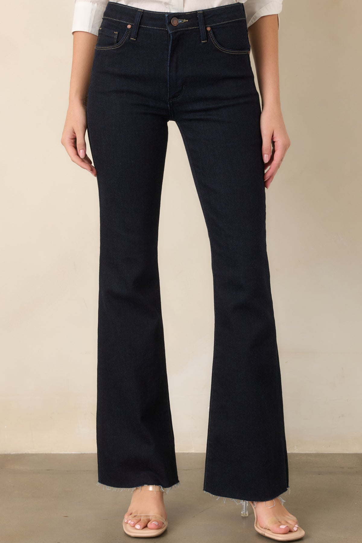 Detailed view of the dark indigo denim showcasing the fitted upper leg and gradual flare beginning below the thigh.