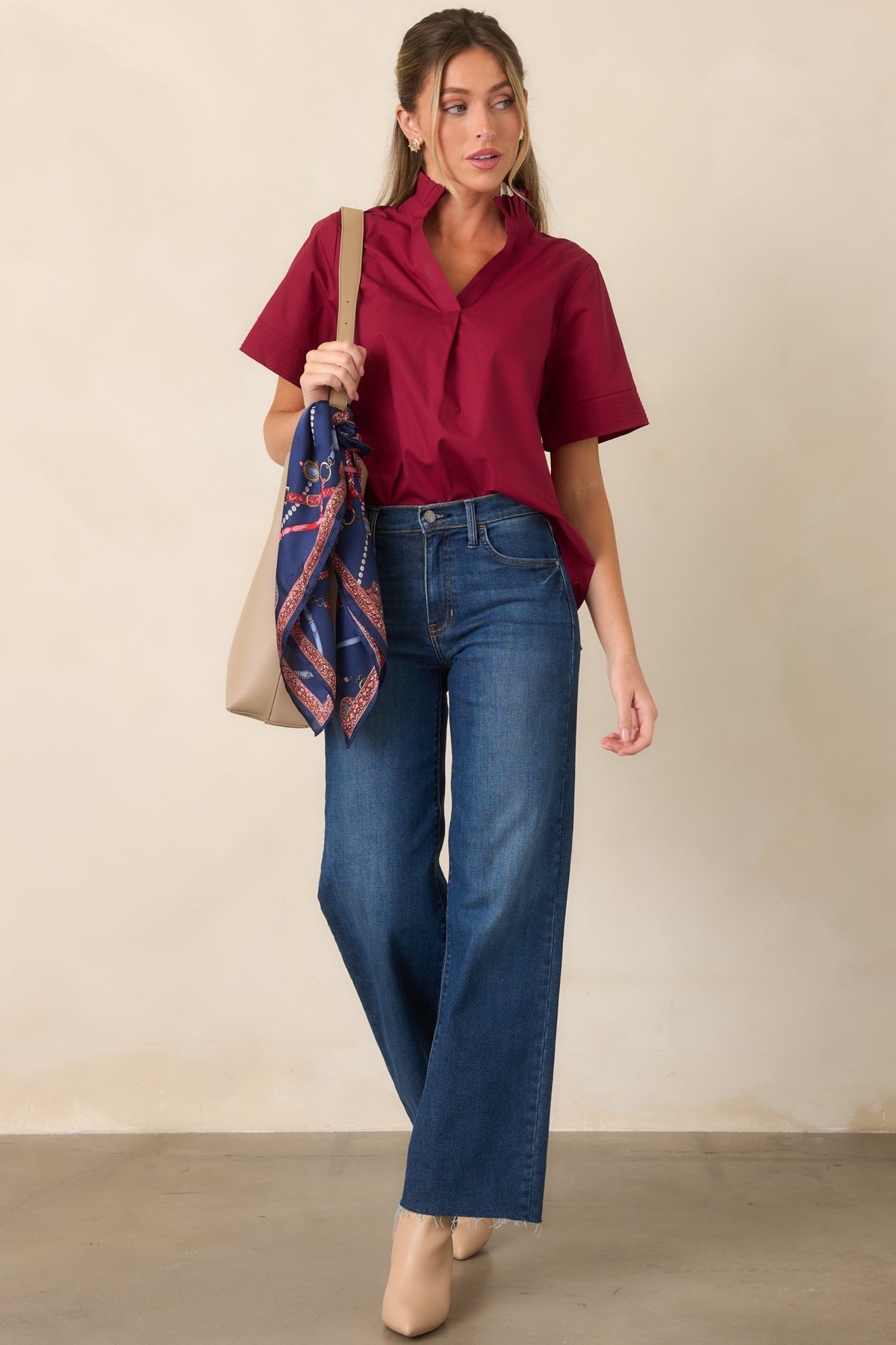 Deep indigo jeans showcasing a structured high waist, straight silhouette, button-and-zip closure, and practical pockets.