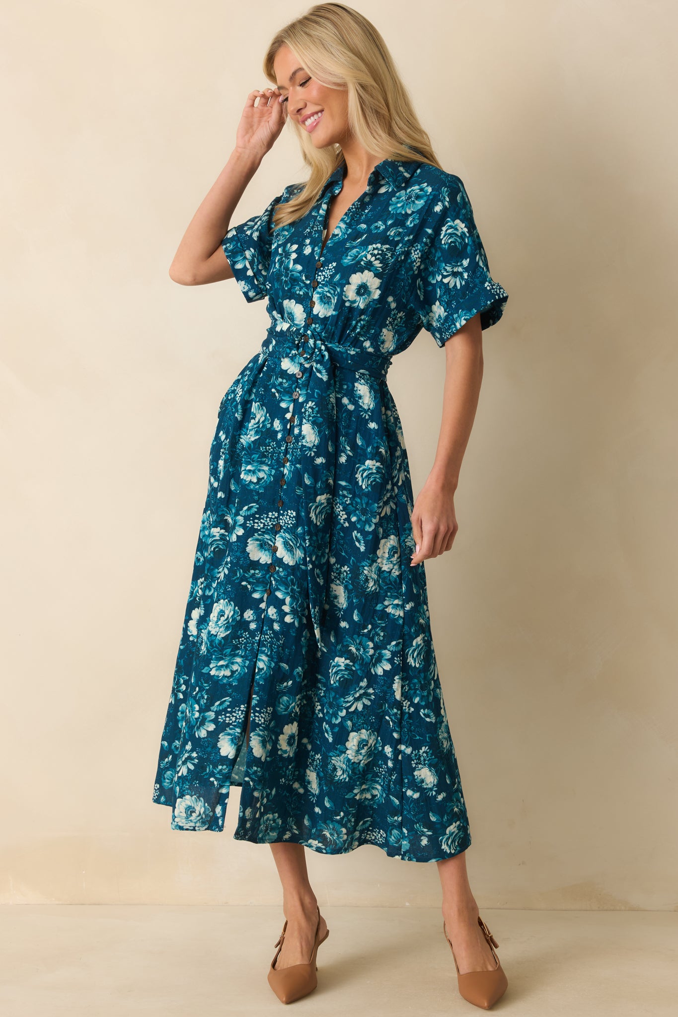 Dark teal floral dress styled with a pull-through belt and cuffed sleeves for a polished, casual look.