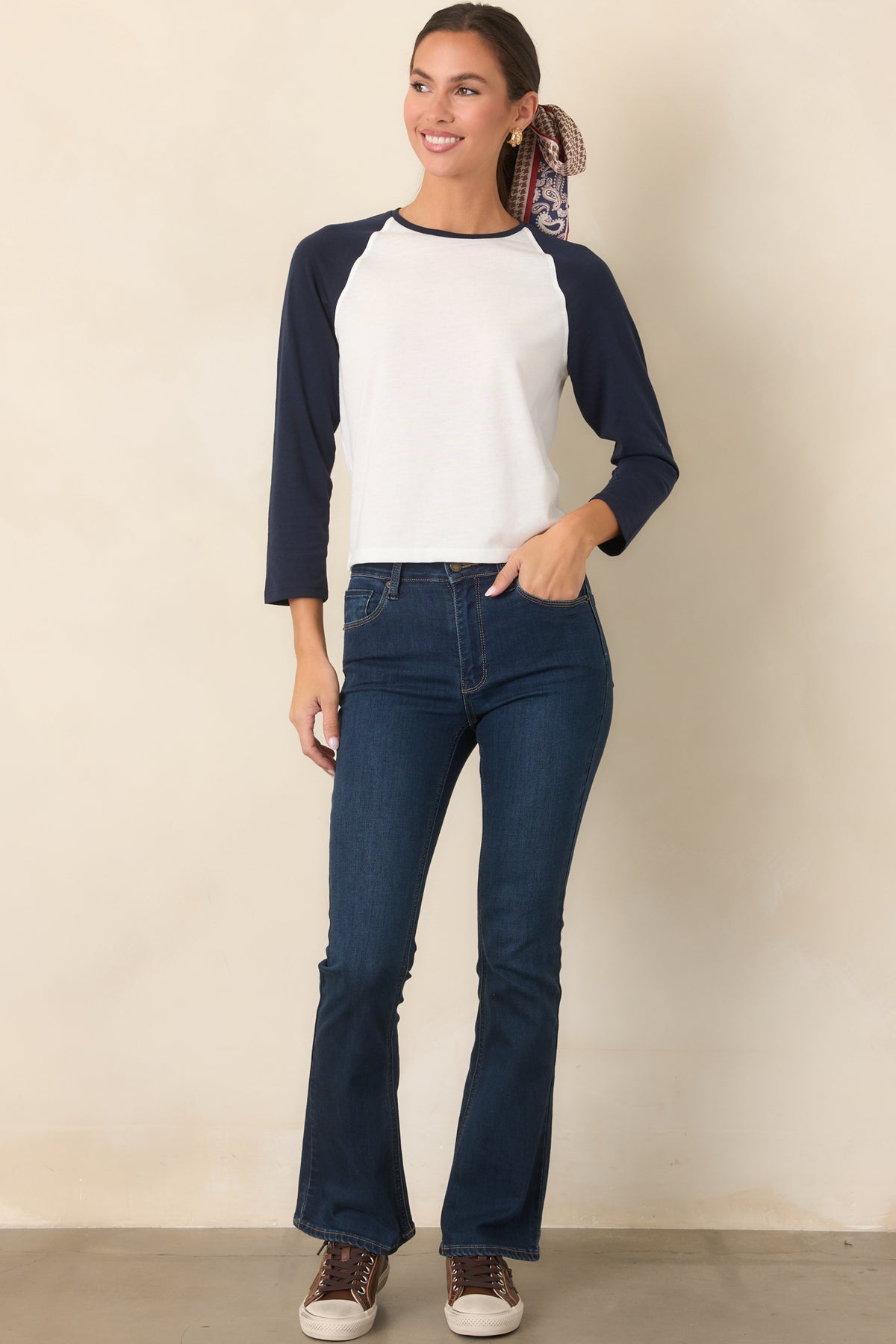 Dark wash cotton-blend jeans featuring a high-rise fit, front button and zipper closure, and flared legs.
