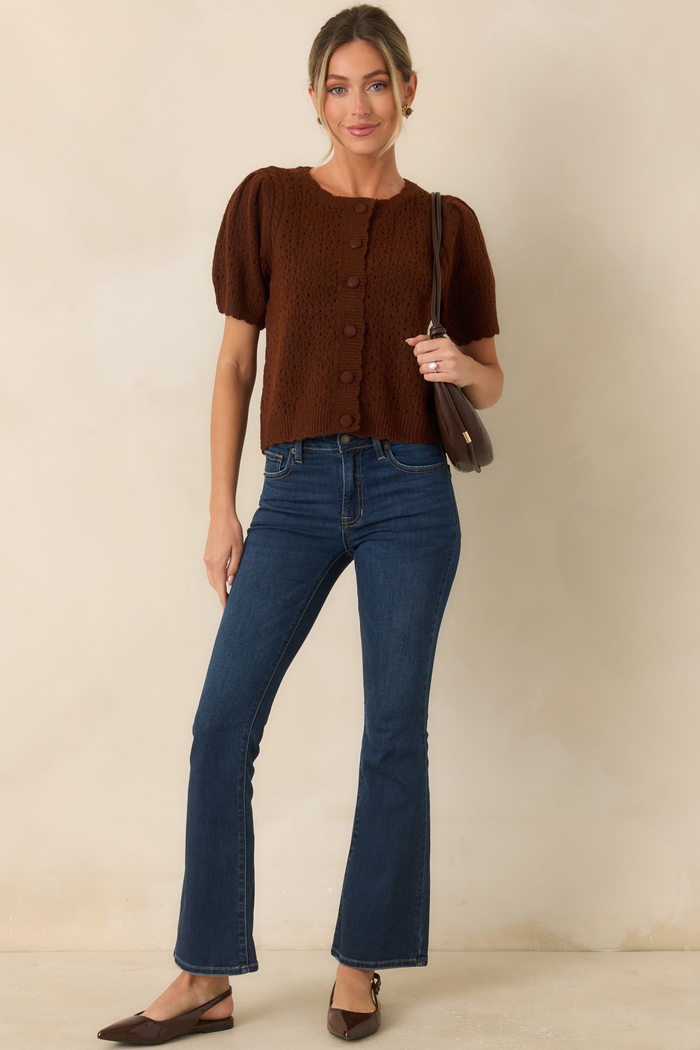 Dark wash cotton denim jeans with a tailored mid-rise fit, subtle flared leg, and clean contrast stitching for a polished finish.