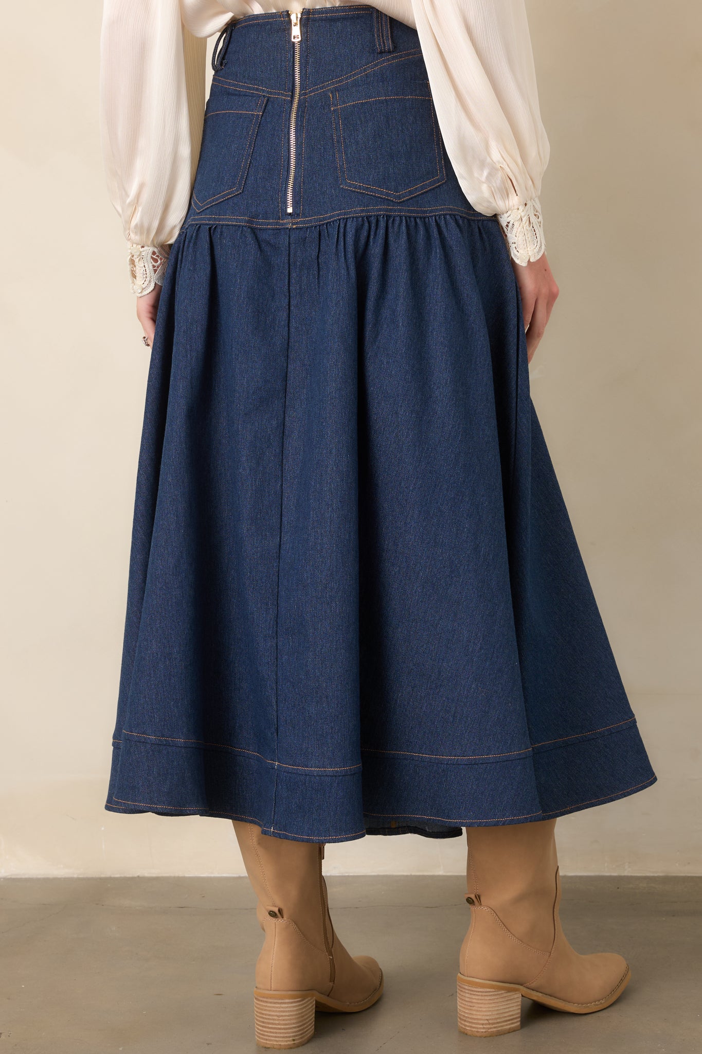 Rear view of the dark wash denim maxi skirt featuring back pockets, structured waistband, belt loops, back zipper closure, and a wide hem.