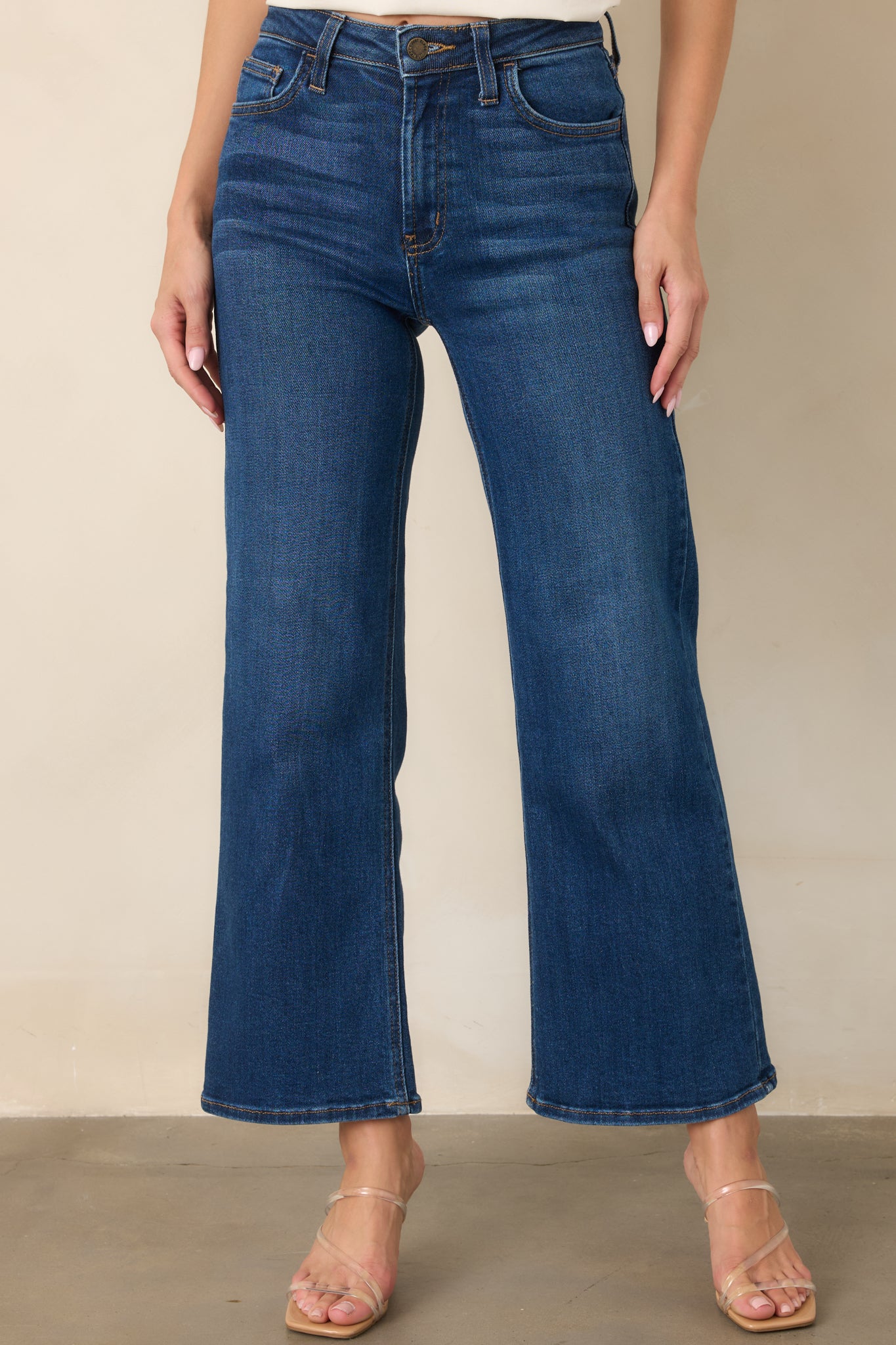 Close view of the dark wash jeans highlighting the high-rise waistband, belt loops, and clean wide leg construction.