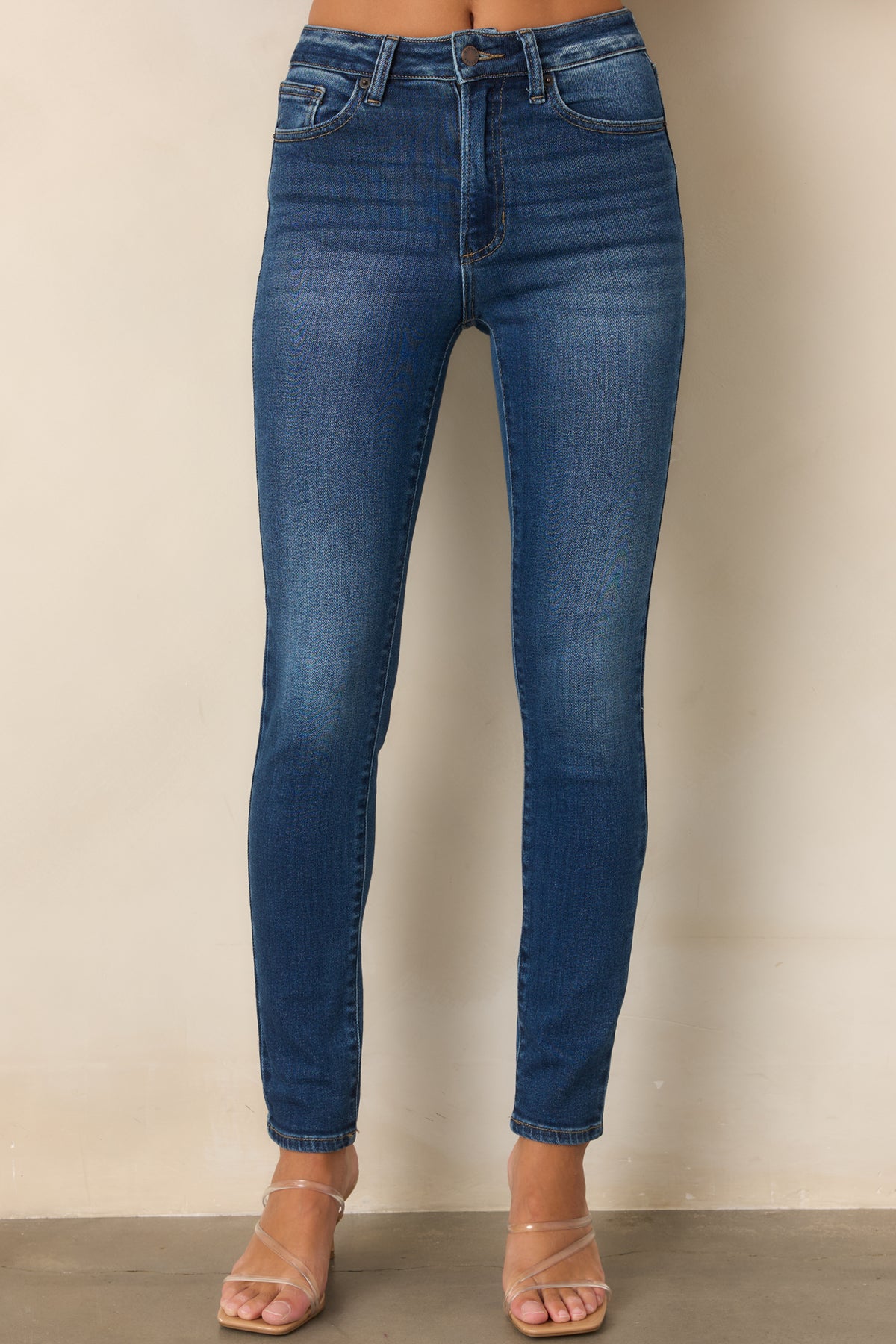 Dark wash high-rise jeans displaying the clean front design and fitted silhouette.