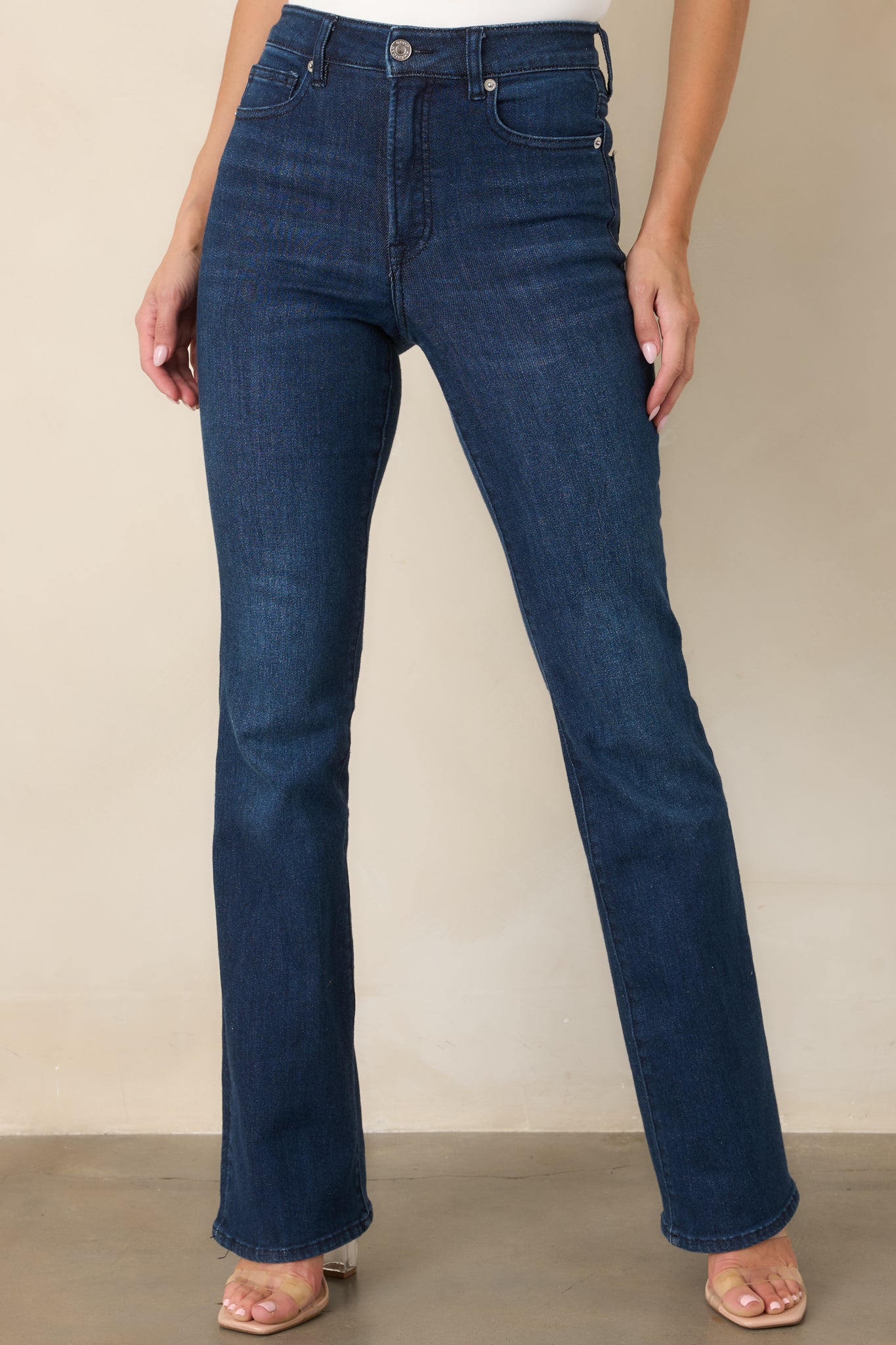 Front detail of the dark wash jeans highlighting the high-rise waistband, belt loops, and classic five-pocket construction.